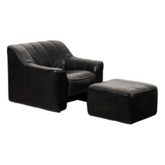 De Sede. Armchair and ottoman in black leather. 1970s