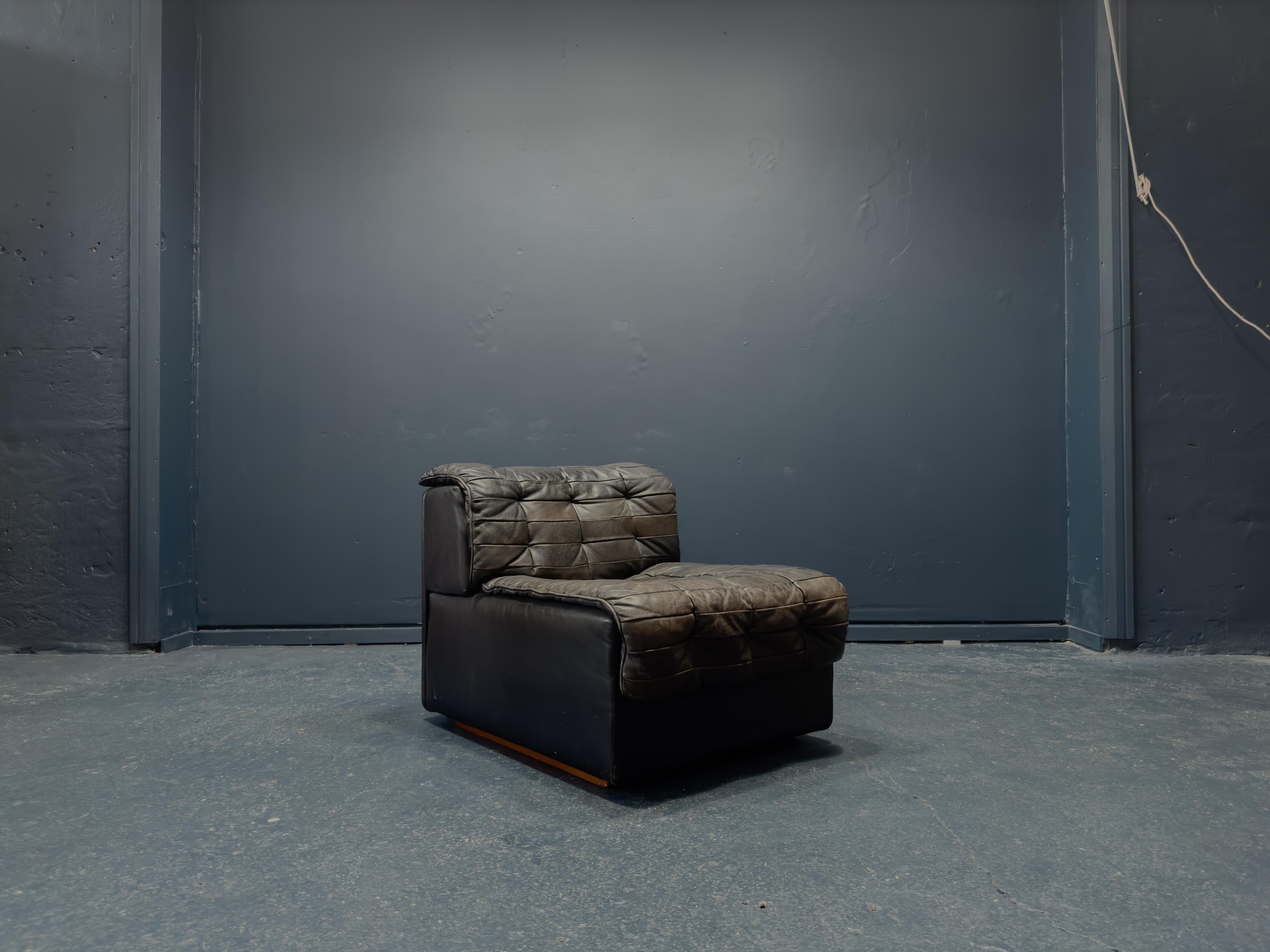 Designed and manufactured by the iconic Swiss company De Sede, this incredible chair is a gorgeous piece of craftsmanship and design. Upholstered in a rich patinated black leather the character and plushness of this design seep through. Made with