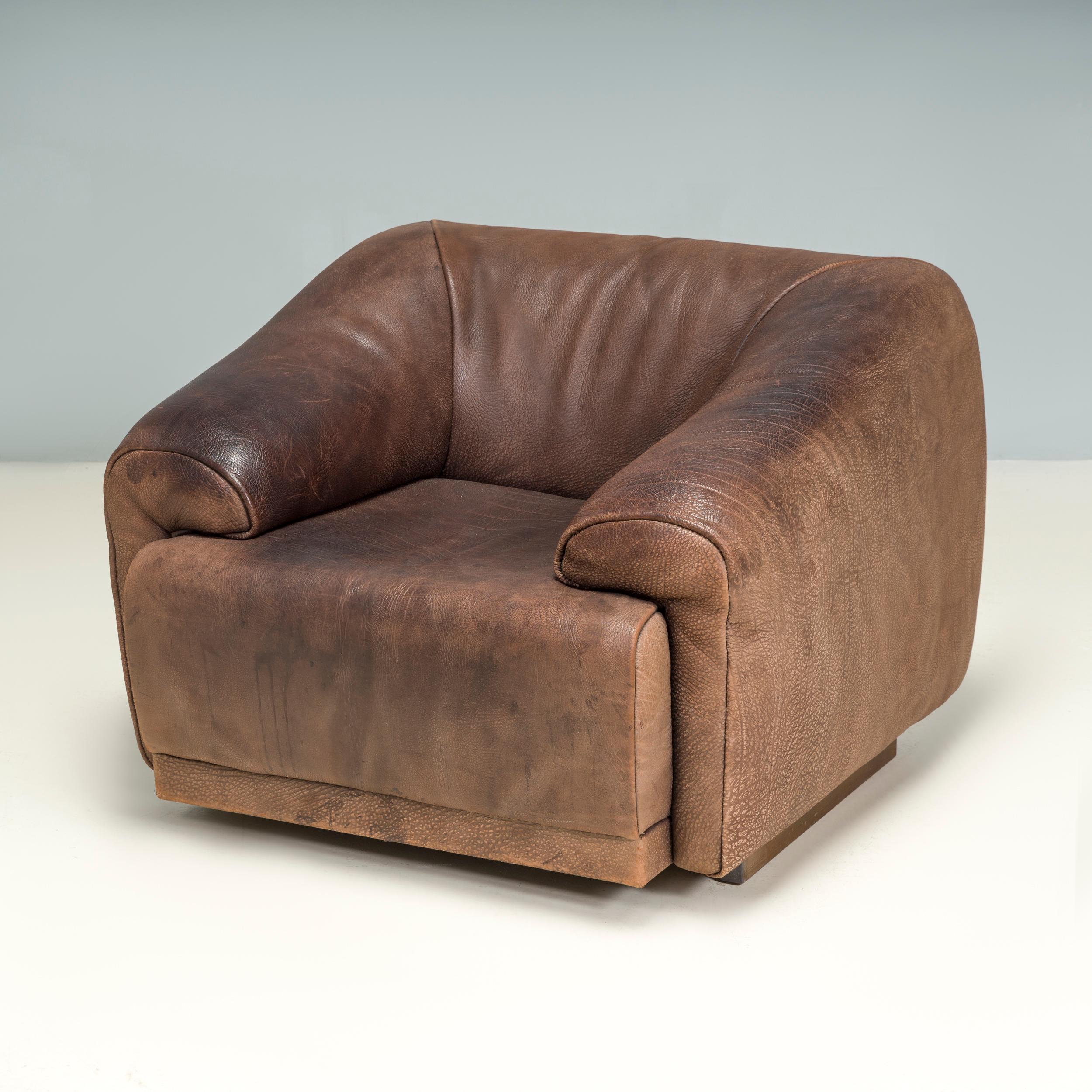 Founded in 1965, the De Sede furniture company has since become best known for their quality leather designs and iconic sofa and armchairs.

Fully upholstered in soft brown buffalo leather, this 1970s armchair has a boxy silhouette in a tuxedo