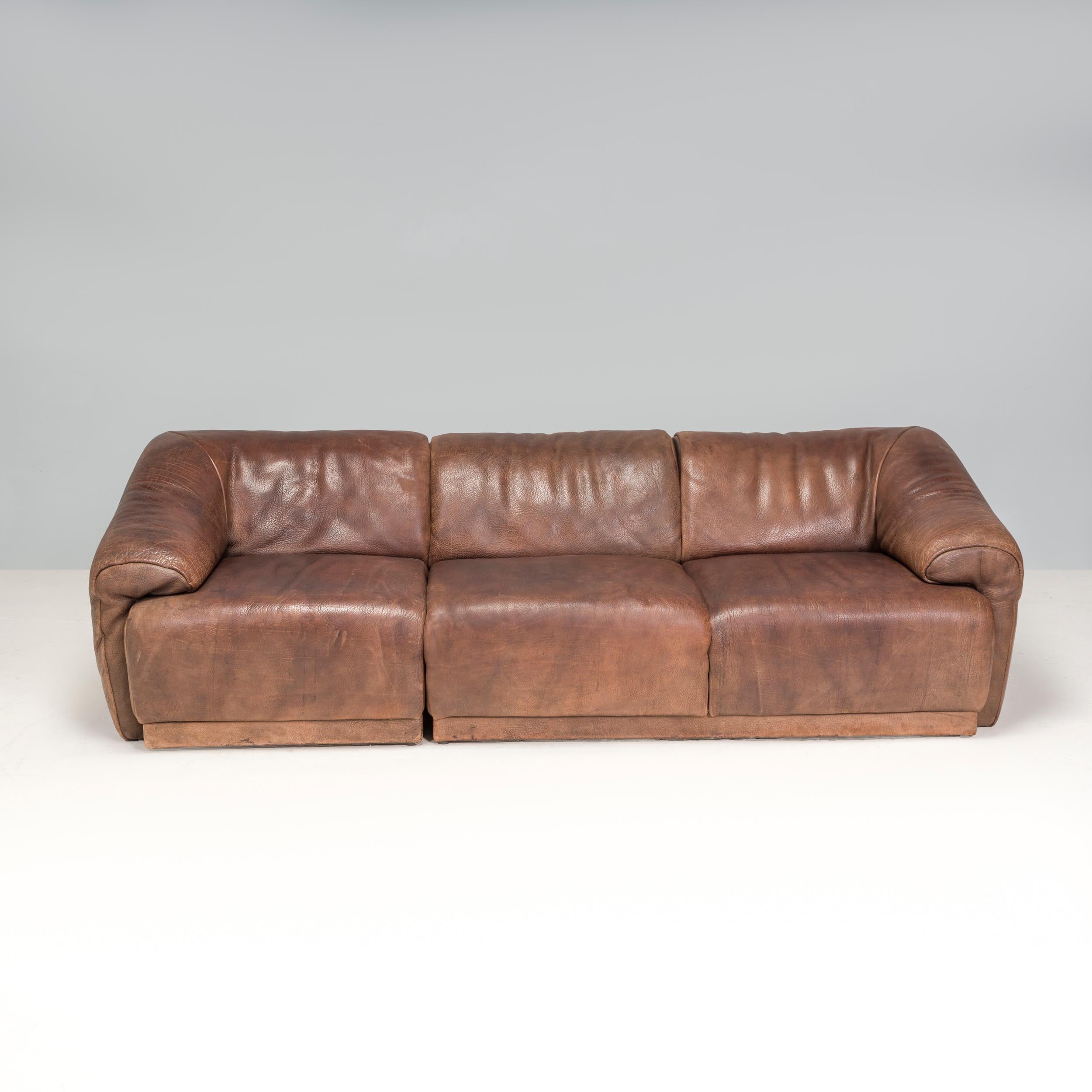 Die 1965 gegründete Möbelfirma De Sede ist seither vor allem für ihr hochwertiges Lederdesign und ihre kultigen Sofas und Sessel bekannt.

Dieses vollständig mit weichem braunen Büffelleder gepolsterte Sofa aus den 1970er Jahren hat eine