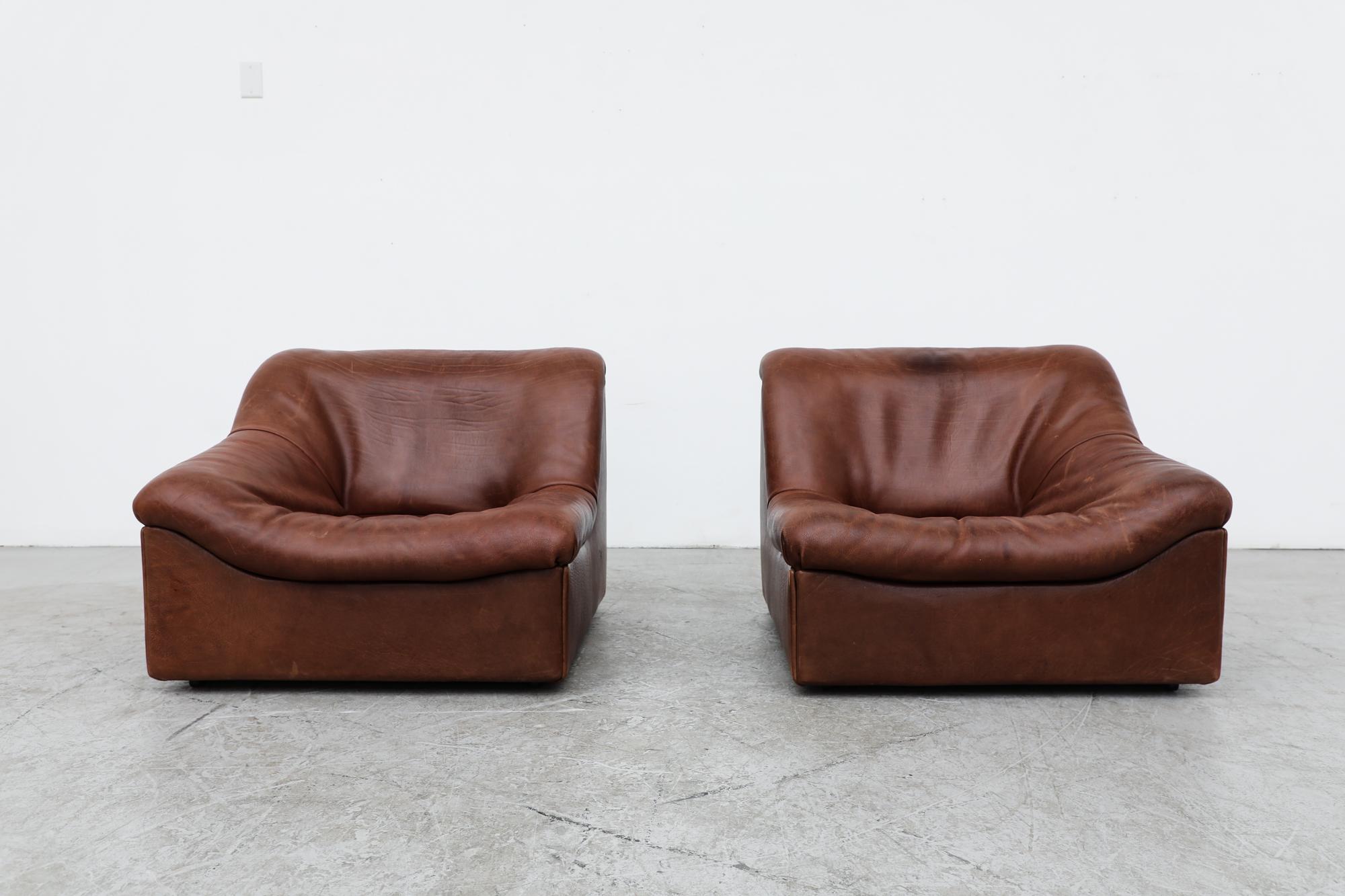Thick leather model DS46 loveseat by De Sede, Switzerland, 1970's with undulating, bucket style seats. In original condition. leather has visible patina and signs of wear, Set price.