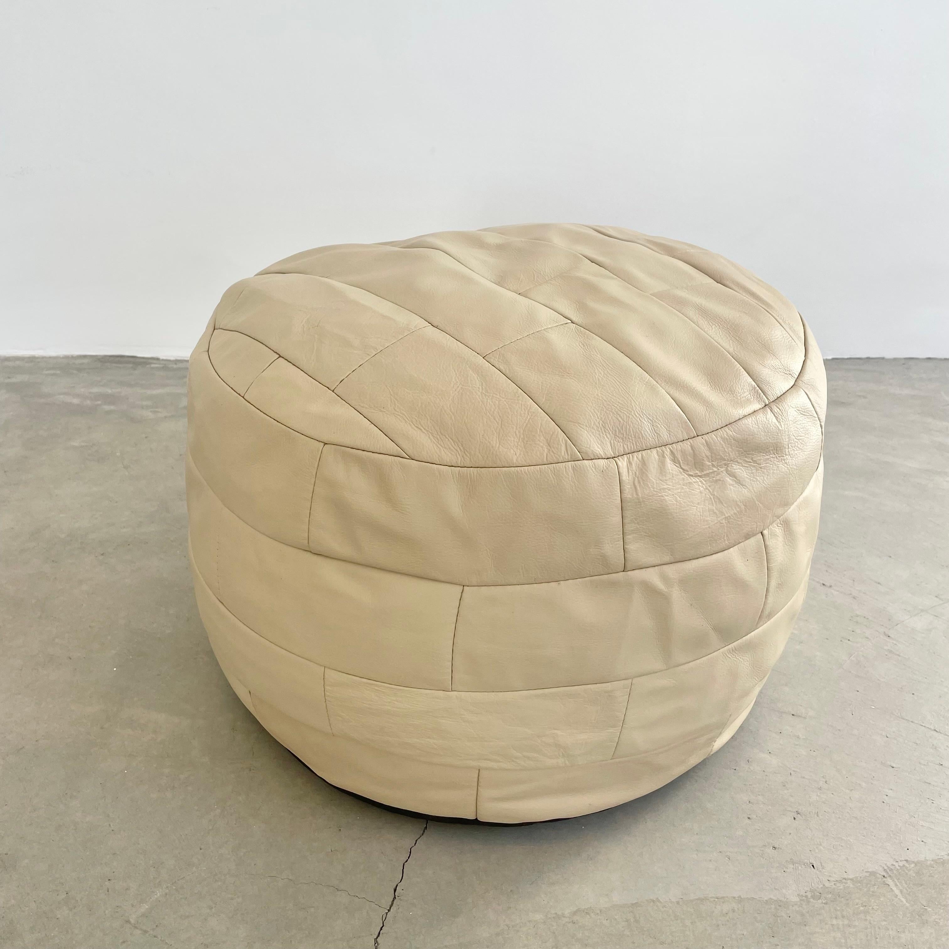 Chic cream leather pouf/ottoman by Swiss designer De Sede with square patchwork. Handmade with wonderful faded patina. Gorgeous accent piece. Good vintage condition. Wear appropriate with age. Brand new filler. Perfect living room decor, foot rest