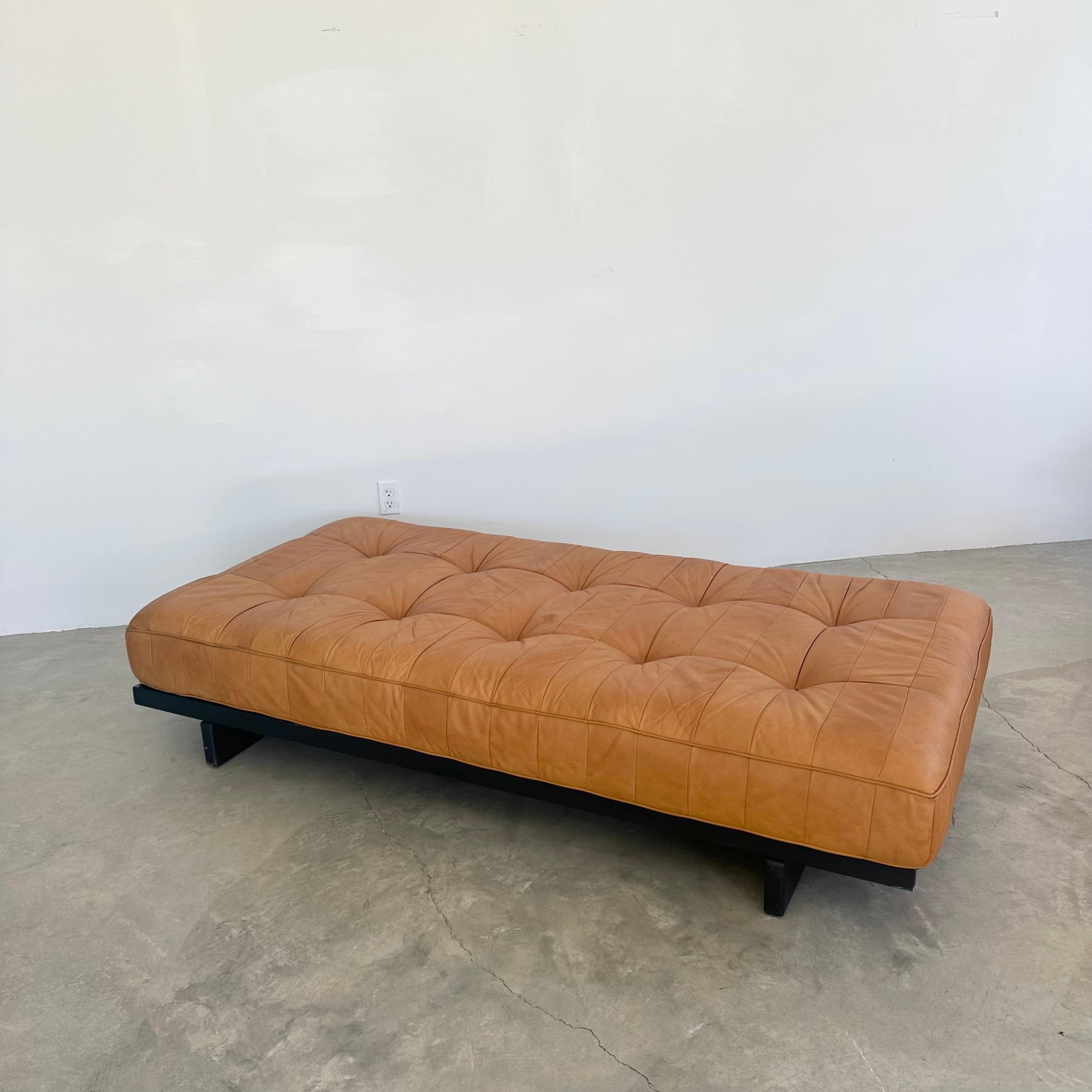Authentic De Sede 80 leather daybed. Switzerland 1960s.

The daybed features a patchwork leather tufted cushion that was recently restored and sits atop a frame made of filigree wood slats. The wood slat frame has a clean, ebonized finish.

This is
