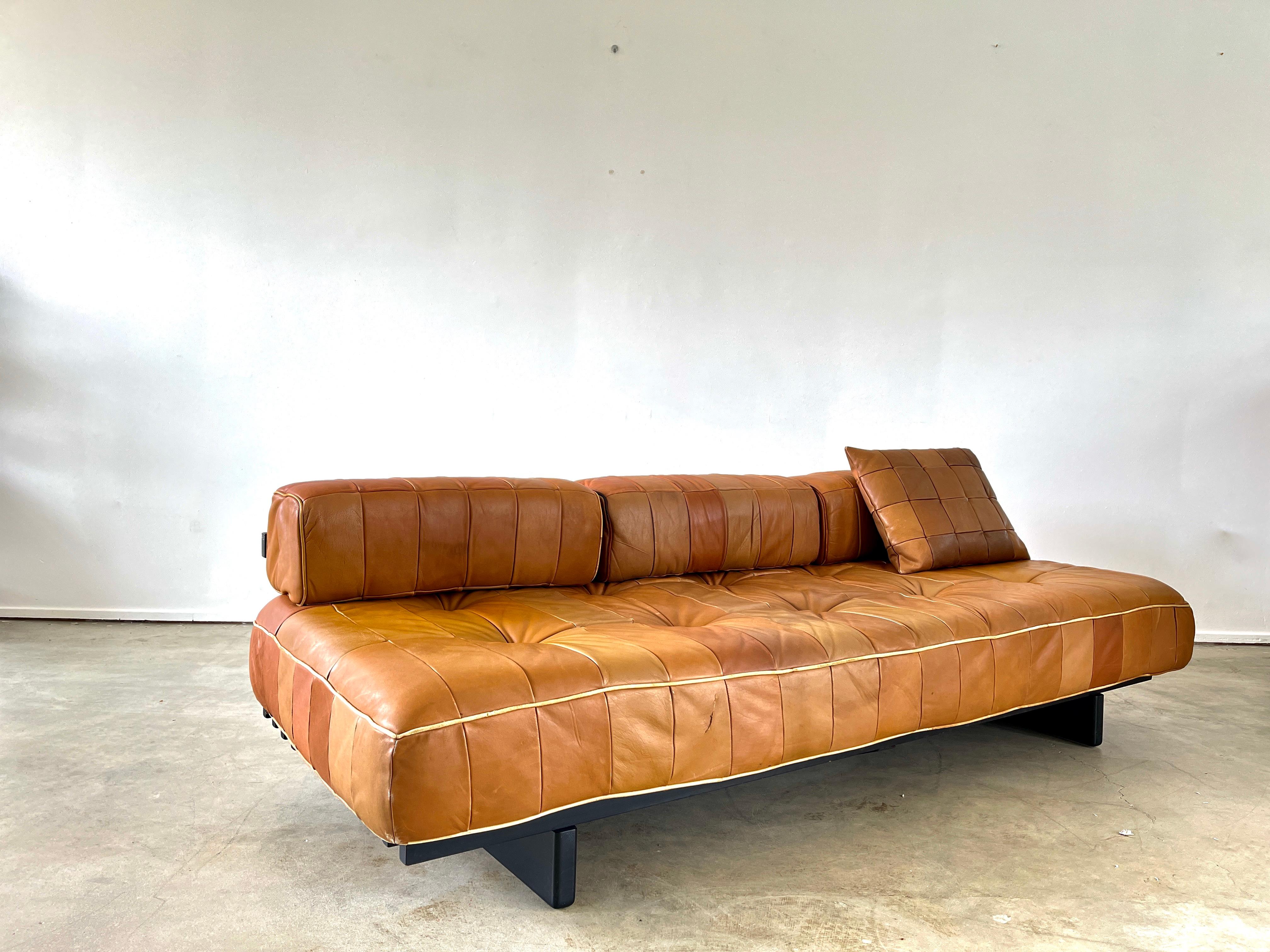 De Sede daybed DS 80 in camel leather with original pillows.
Signature patchwork leather has wonderful patina and sits on a slatted bench.
Slatted black wood frame.