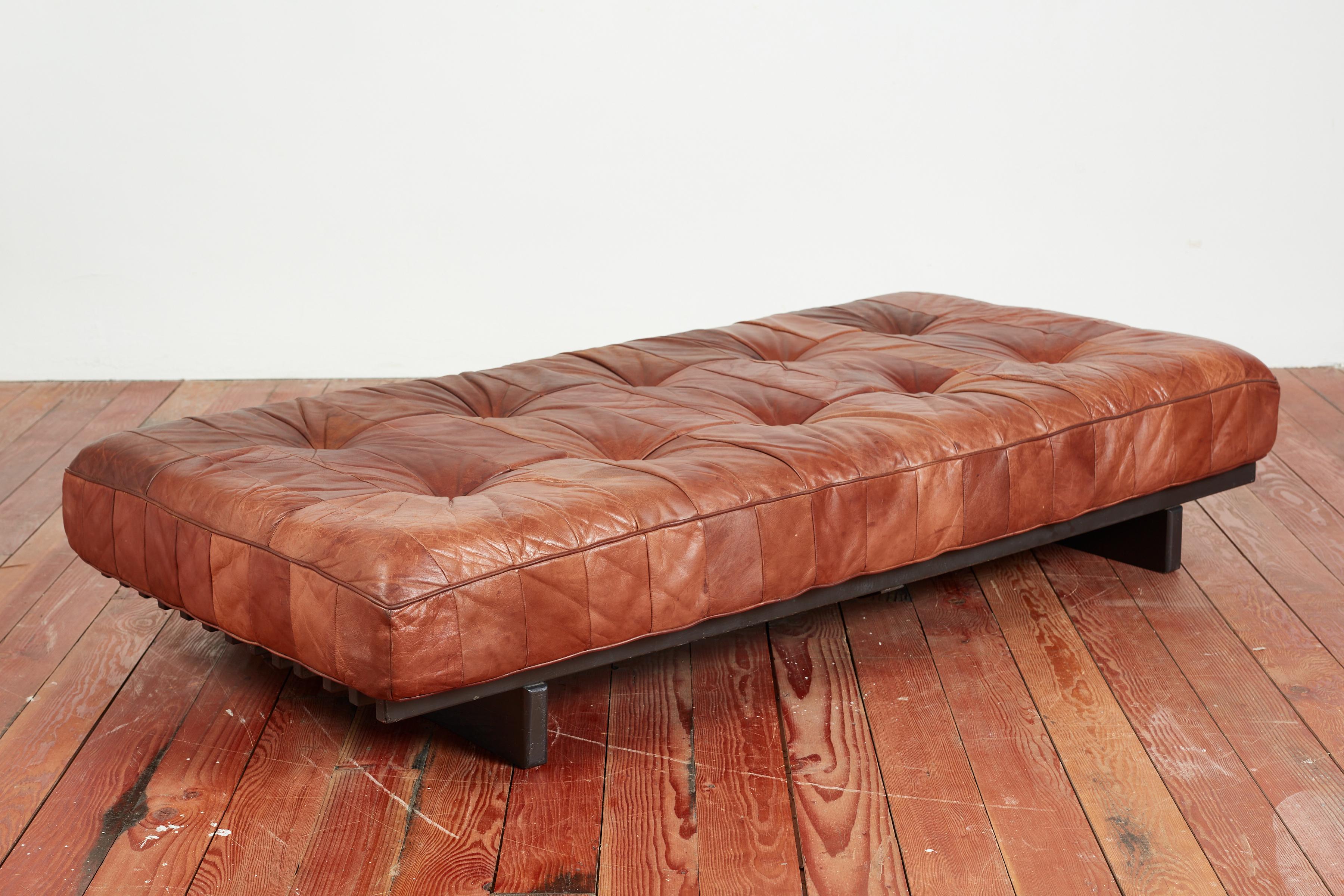 Wonderful De Sede daybed DS 80 in rich caramel brown leather.

Signature patchwork leather has wonderful patina and sits on a black slatted wood frame.
