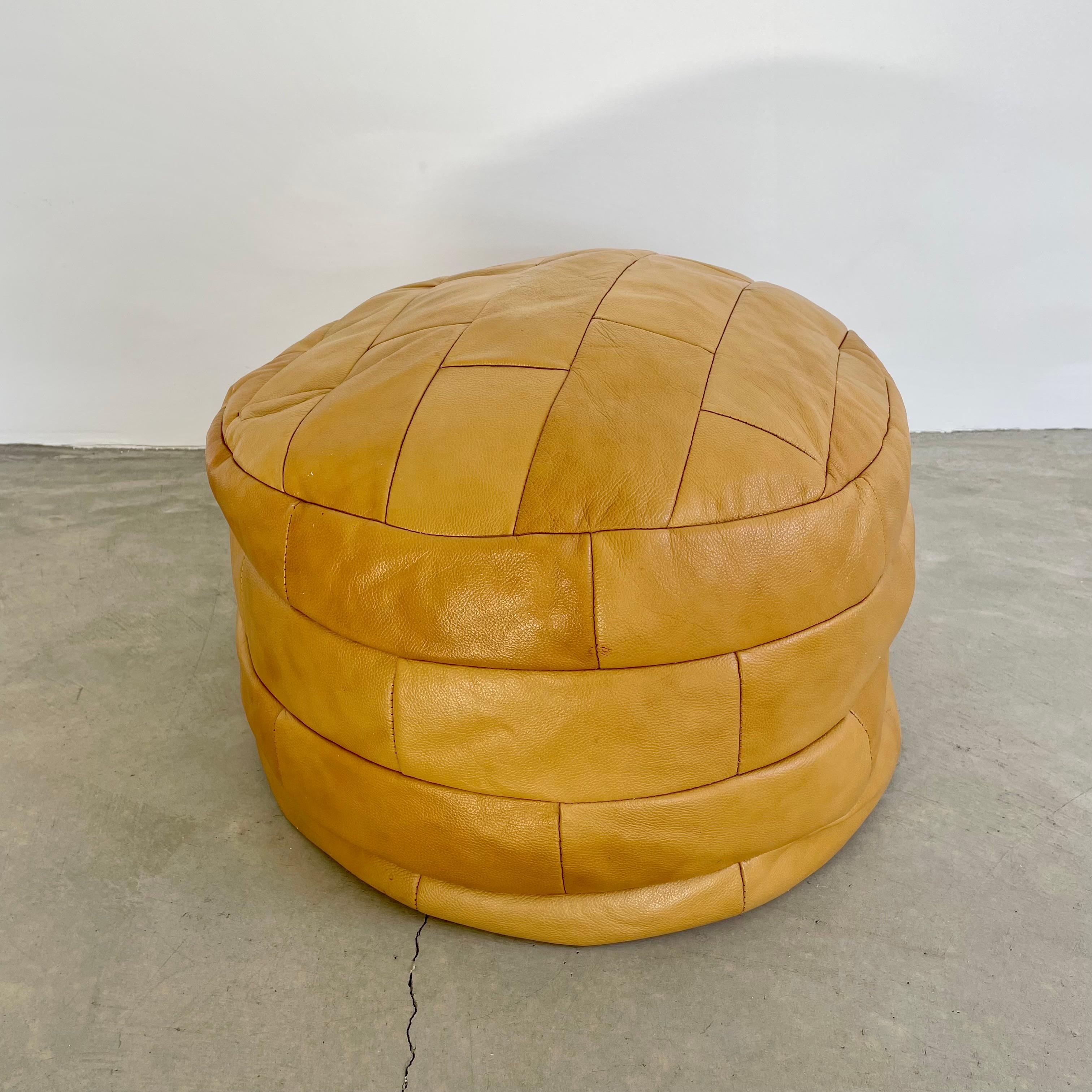 Gorgeous deep tan-colored leather pouf/ottoman by Swiss designer De Sede with square patchwork. Handmade with wonderful faded patina. Gorgeous accent piece. Good vintage condition. Wear appropriate with age. Brand new foam beads. Perfect living room