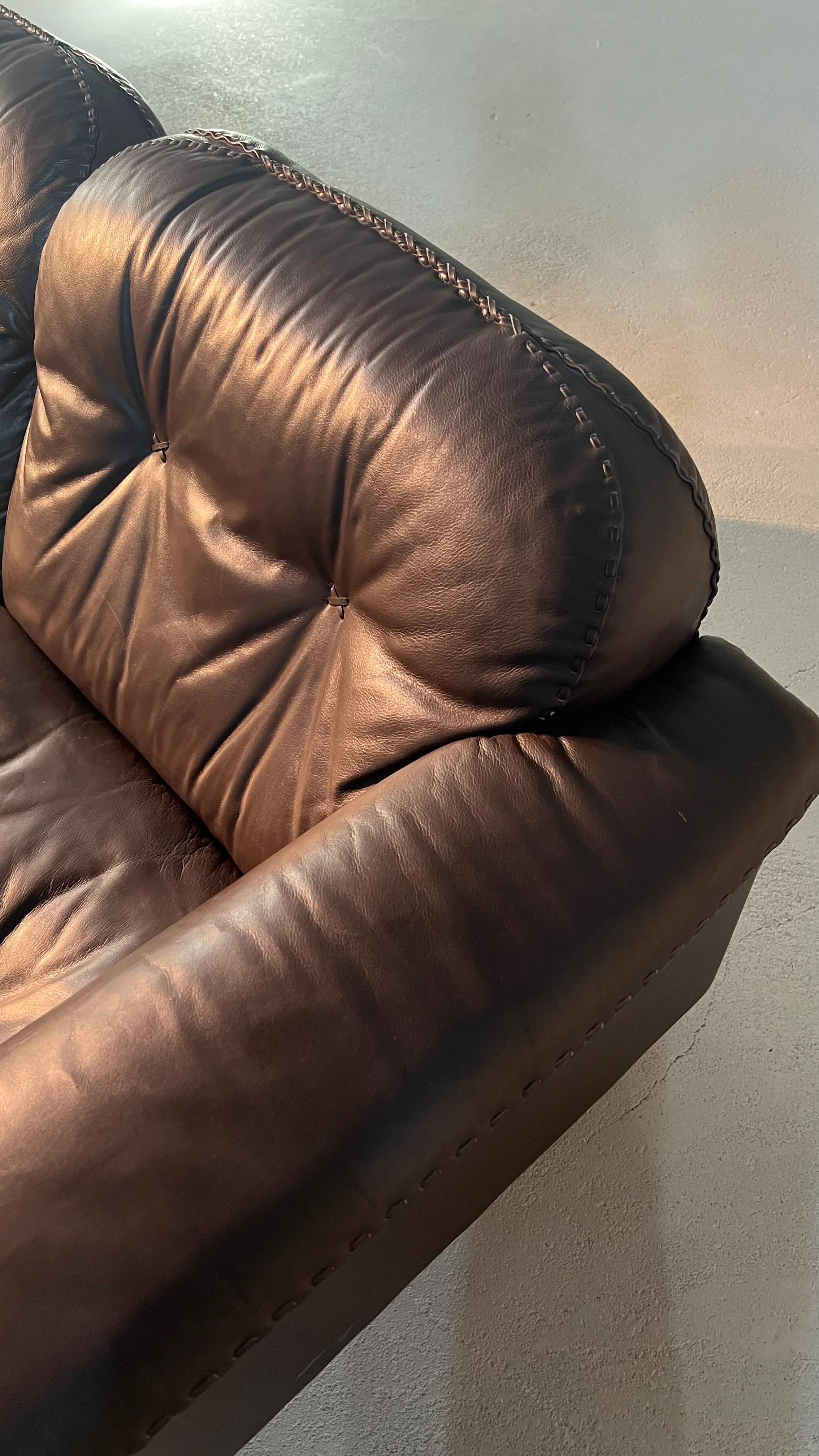 Canapé design suisse de haute qualité fabriqué par le célèbre fabricant artisanal de meubles De Sede. Le cuir marron et les surpiqûres de baseball confèrent à ce midcentury un caractère brutaliste typique. L'assise et le dossier peuvent être réglés