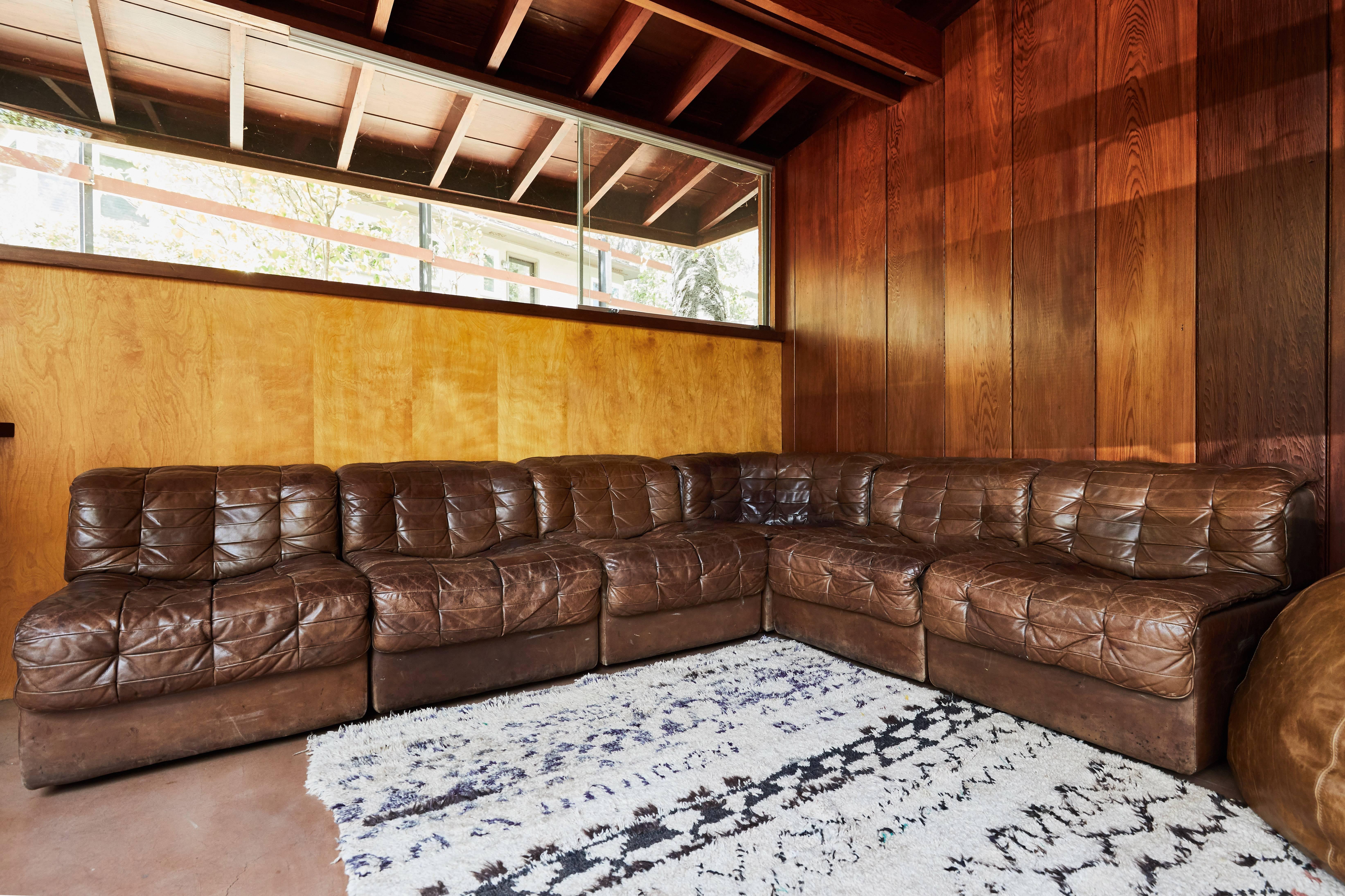 De Sede DS 11 patchwork leather Sectional Sofa. Executed in patinated brown patchwork leather and manufactured by De Sede of Switzerland in the 1970s. A six-pieces modular design that can be arranged individually or in a single configuration.