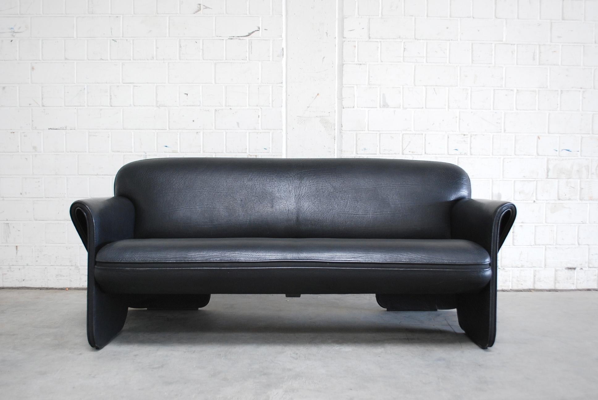 De Sede model Ds 125 neck leather sofa.
Design by German designer Gerd Lange.
3-seater sofa with sculptural curved lines and zip details on the armrests.
It’s a thick neck leather in light black color.
It’s not the darkest black.
The sofa is in