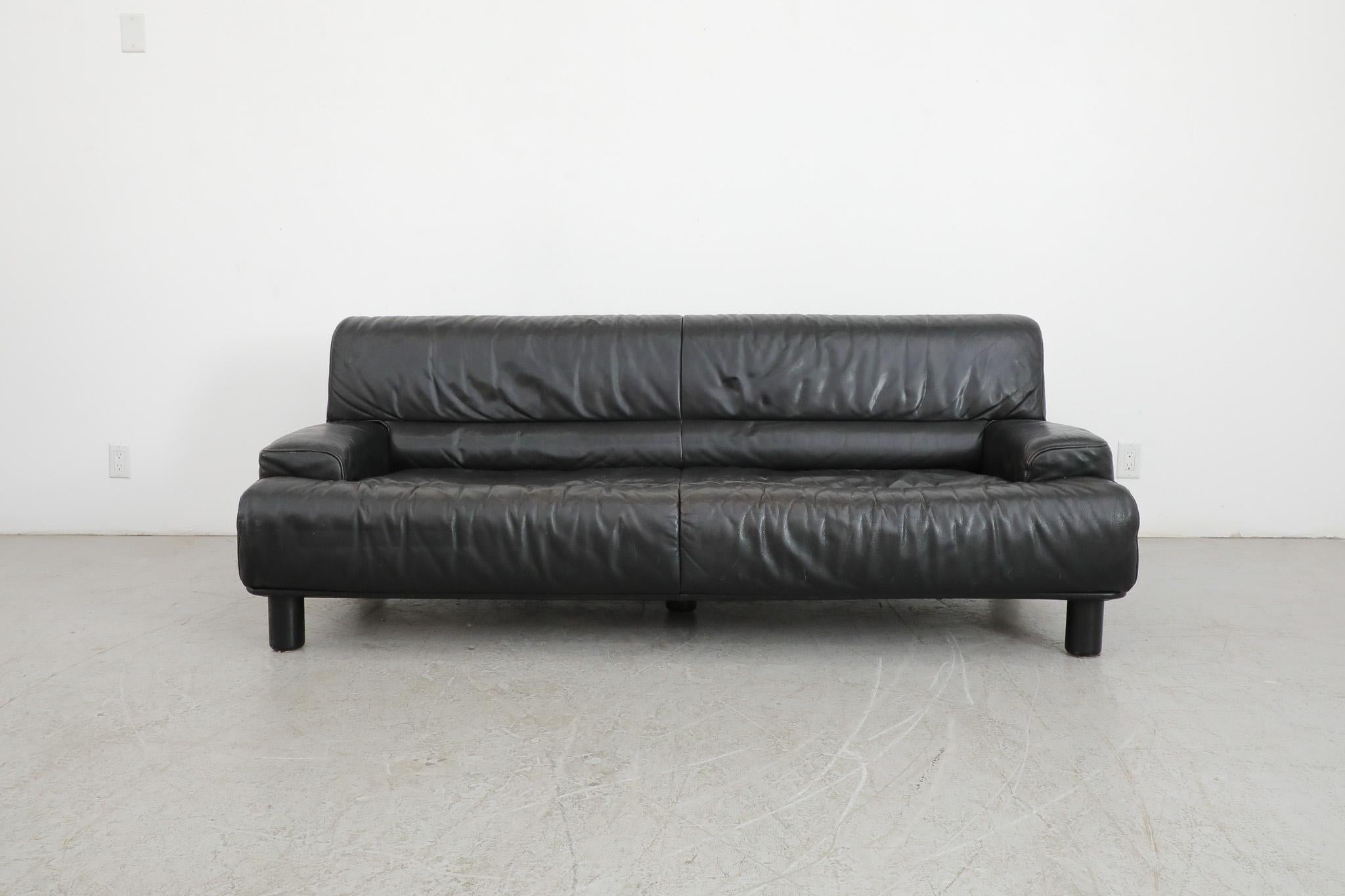Mid-Century 'DS-18' black leather sofa with black wood legs by iconic Swiss leather furniture manufacturer De Sede. Plush, generously sized 3 seater sofa perfect for  high comfort lounging. In original condition with some visible wear and scratching