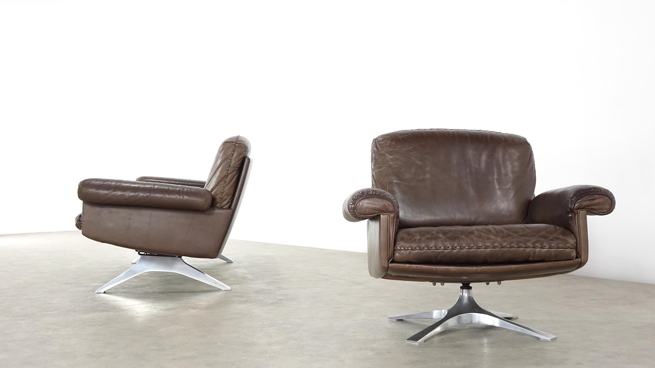 De Sede DS 31 lounge sofa and swivel armchair were built in the 1970s by De Sede of Switzerland. They are upholstered in brown leather with whipstitch edge detail. Both pieces are very comfortable and Stand on aluminium bases. De Sede is known by