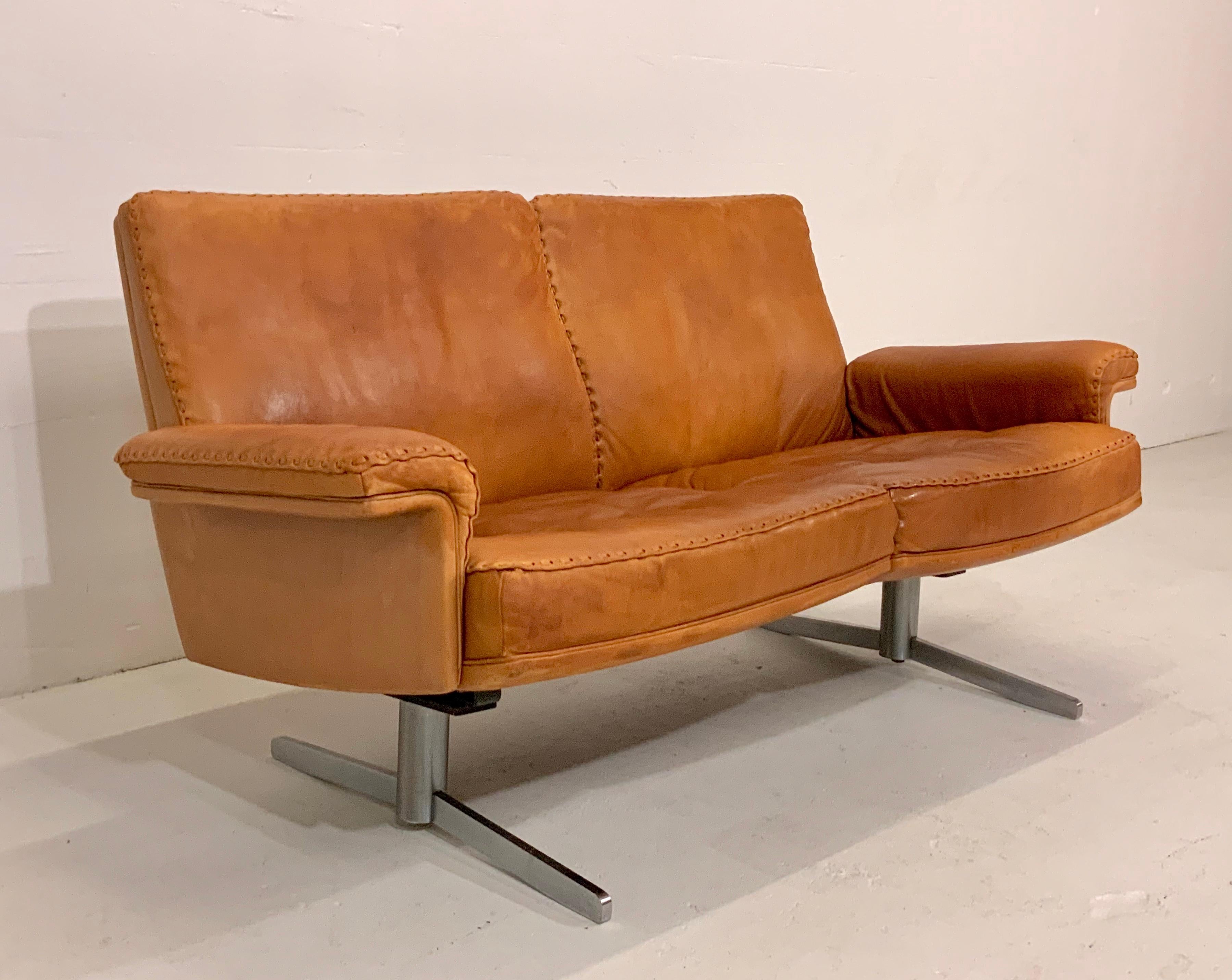 This very rare iconic Mid-Century Modern leather lounge sofa is from the renowned leather manufacturer De Sede (Switzerland) and a popular 1960s-1970s vintage design Classic. It comes in smooth and soft aniline cognac brown leather and is from