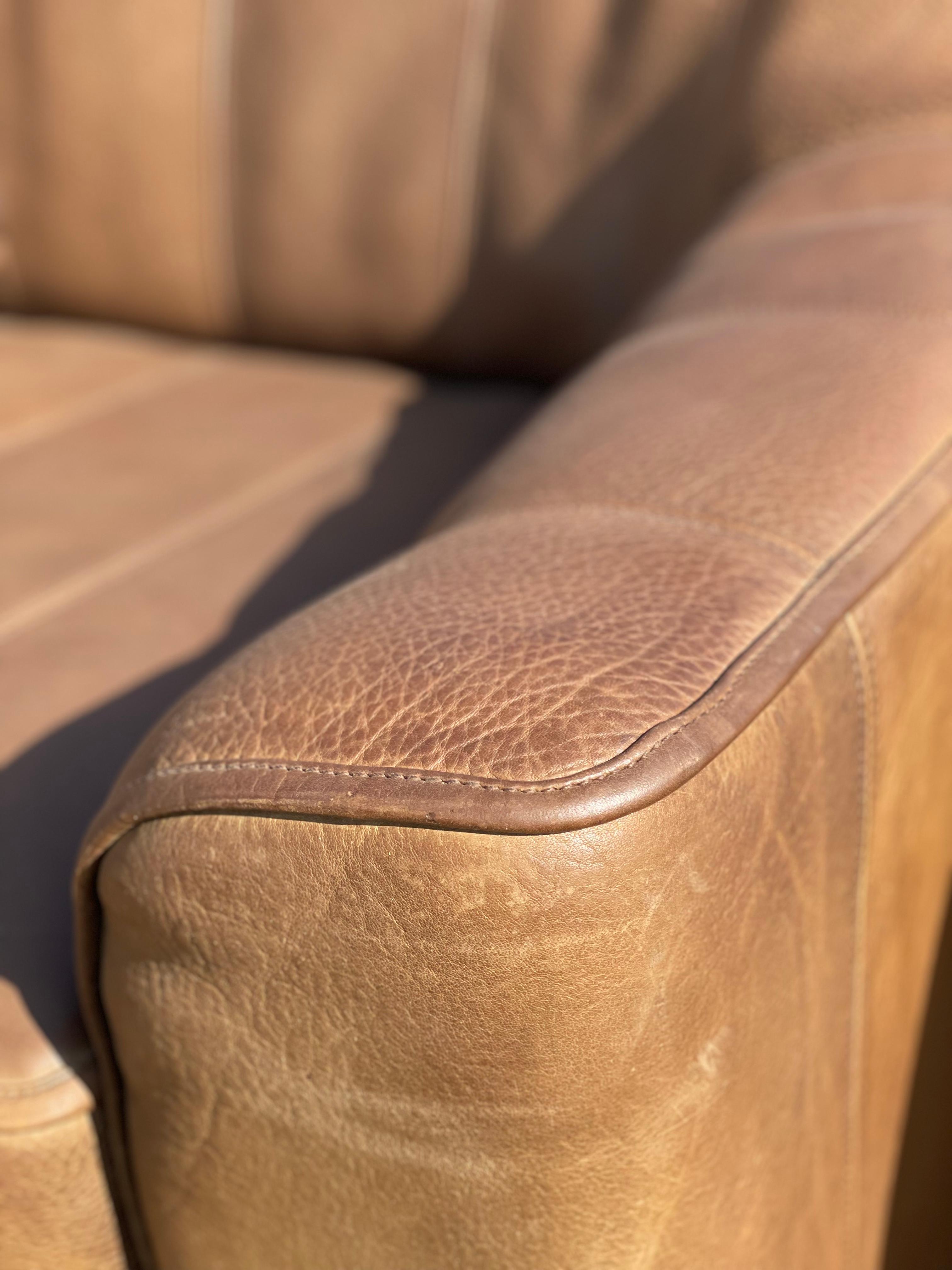 The DS 44 2 seat comfort leather block style sofa is designed and produced by De Sede in Switzerland. This beautiful 2 seat sofa is in a patina chocolate brown buffalo leather that features vertical stitching on the seat and seat back. The leather