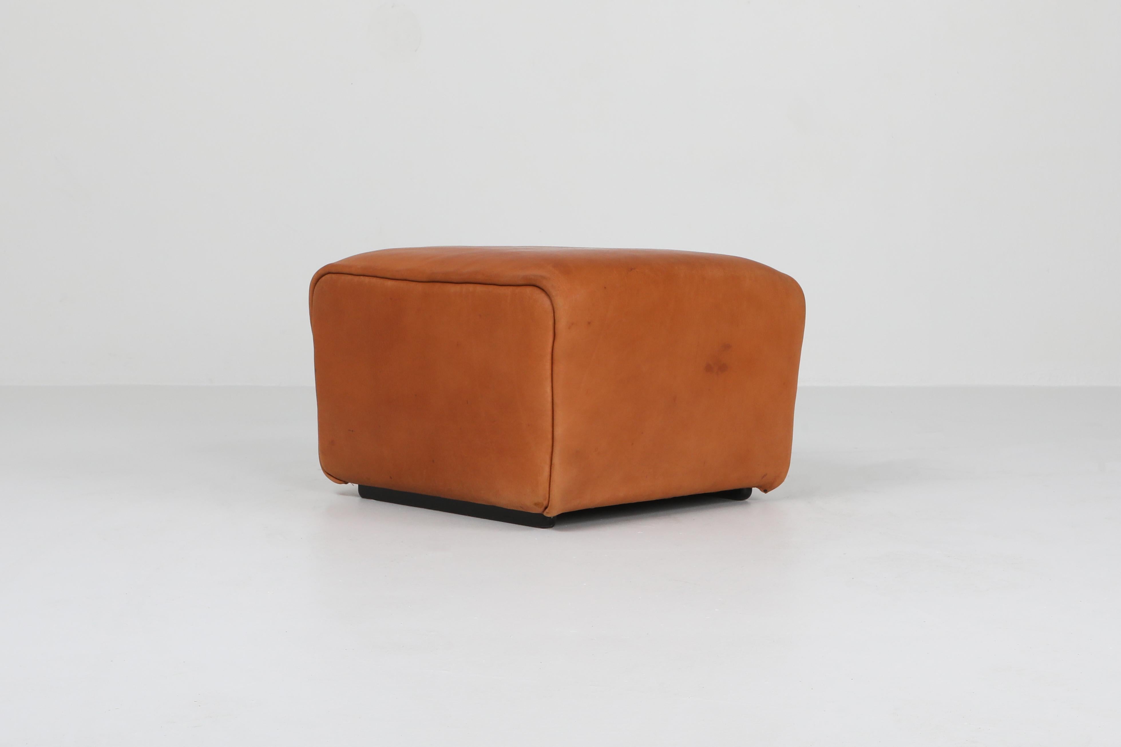 Cognac leather ottoman by Swiss manufacturer De Sede.

The DS models are true design Classics and are still in production. These are original ottomans with tons of character and a great patina you only get with age.
thick buffel hide