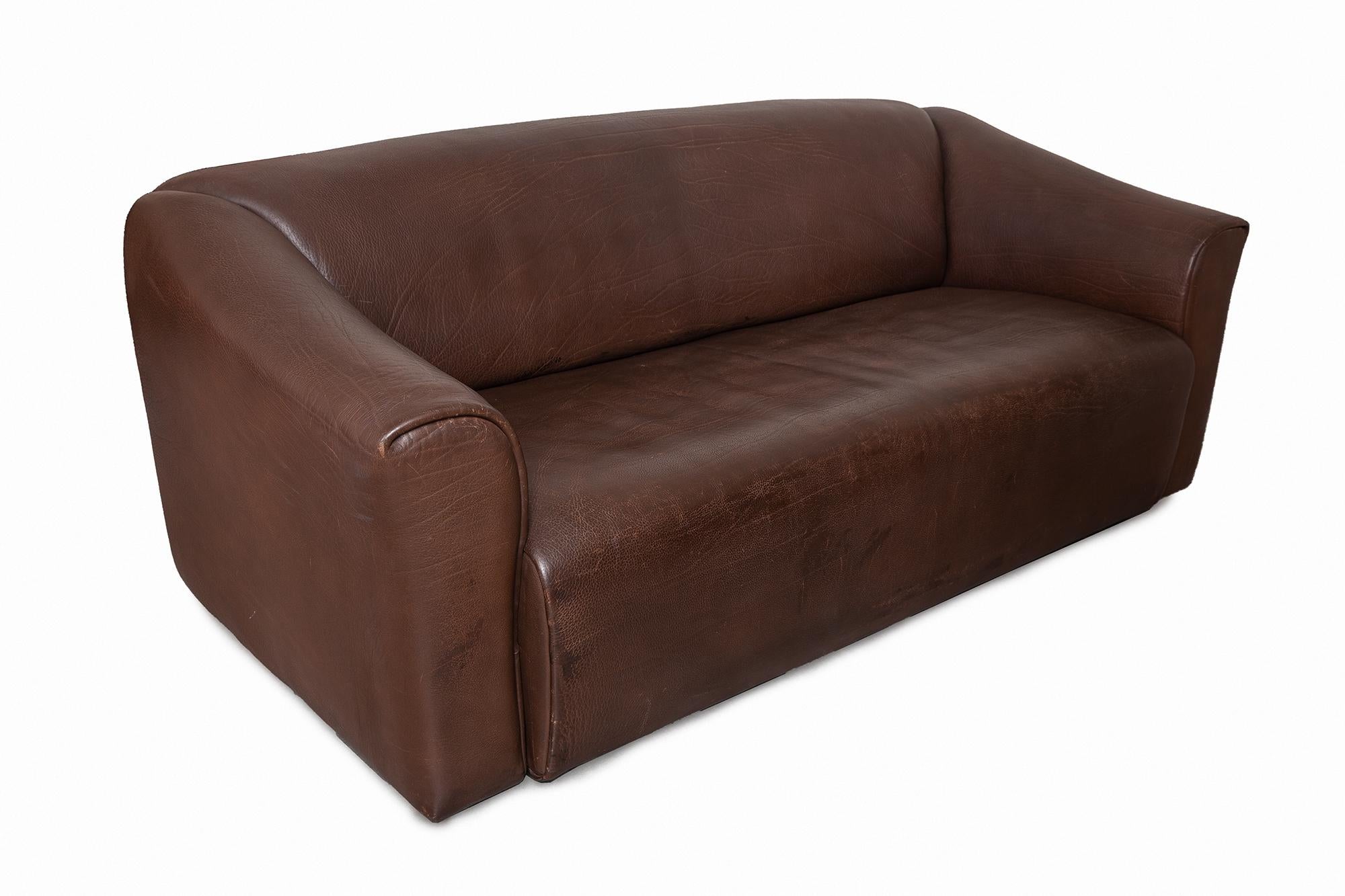 “DS-47” sofa by De Sede, Switzerland, 1970s. Made of thick bull leather which is laid in one piece and folded over the frame. Chocolate brown leather in great condition. The sofa has the incredible ability to increase your comfort with the seating