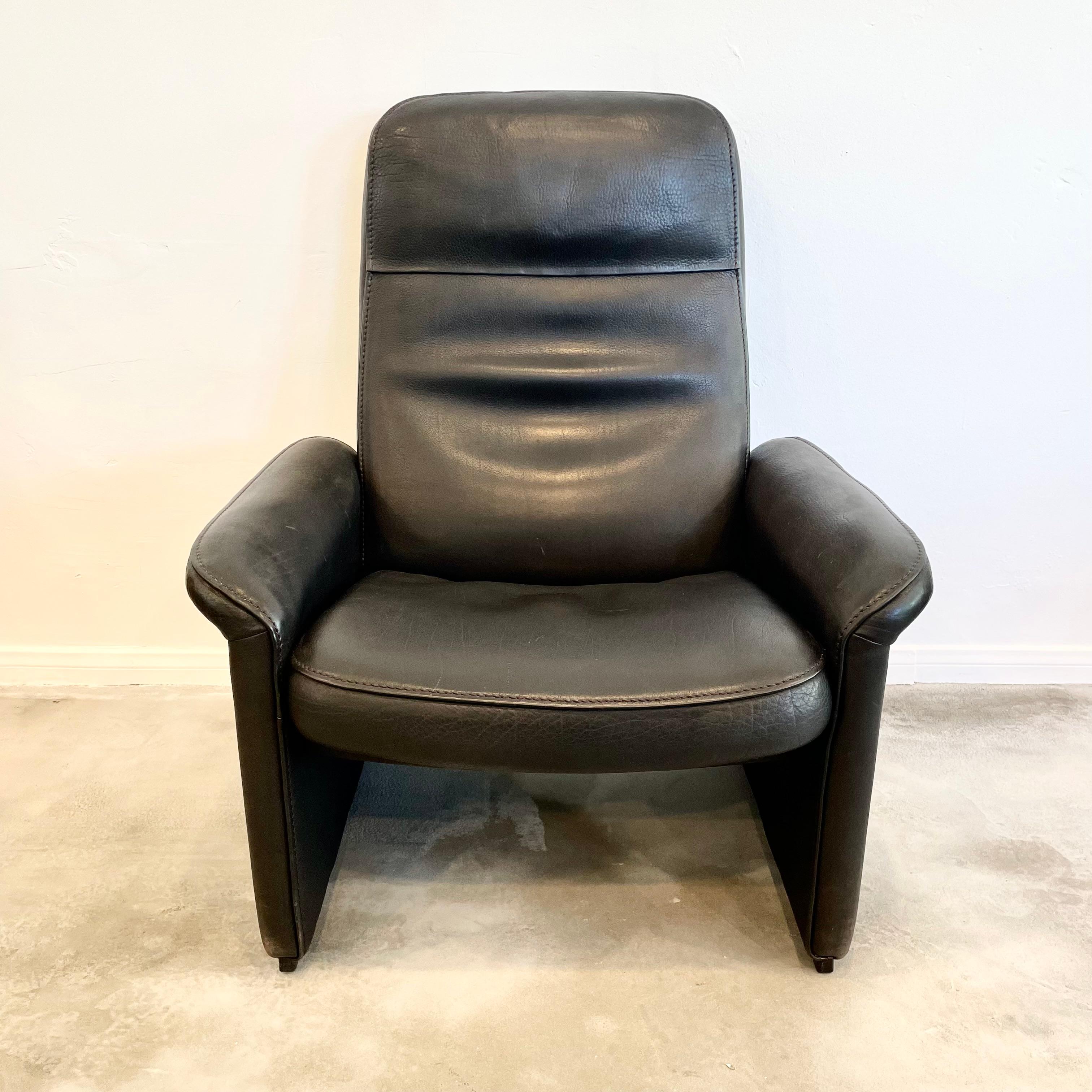 Executive lounge chair by De Sede made in the 1970s, Switzerland. Features a reclining mechanism allowing you to recline the chair almost flat if you choose. Extremely comfortable. This piece has a solid wooden frame with hand-stitched with black