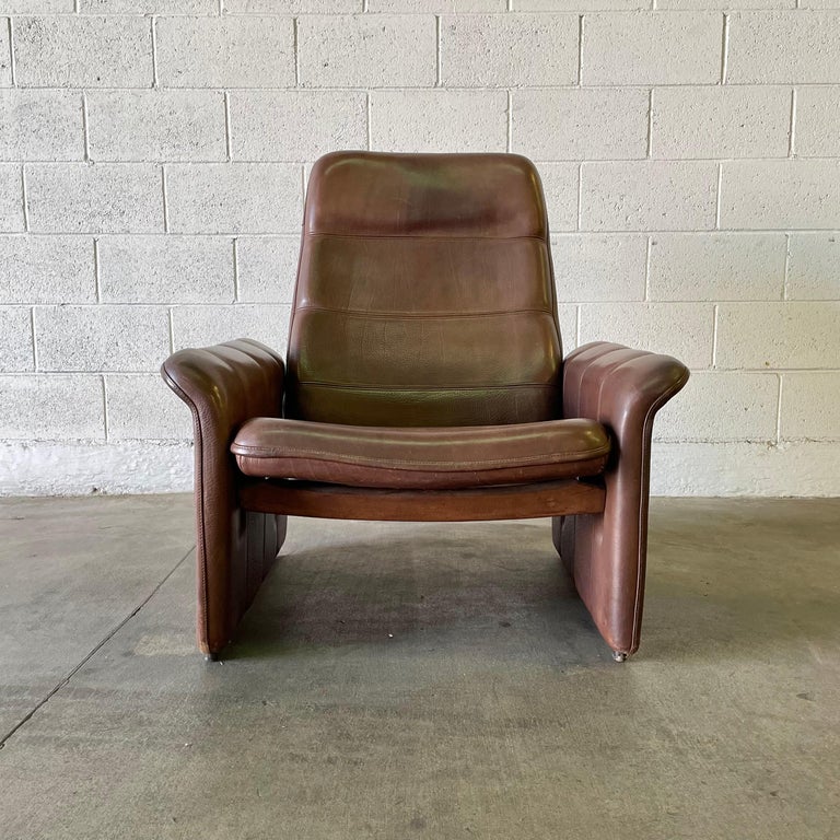 Executive lounge chair by De Sede made in the 1970s, Switzerland. Features a reclining mechanism allowing you to recline the chair almost flat if you choose. Extremely comfortable. This piece has a solid wooden frame, is hand-stitched with supple