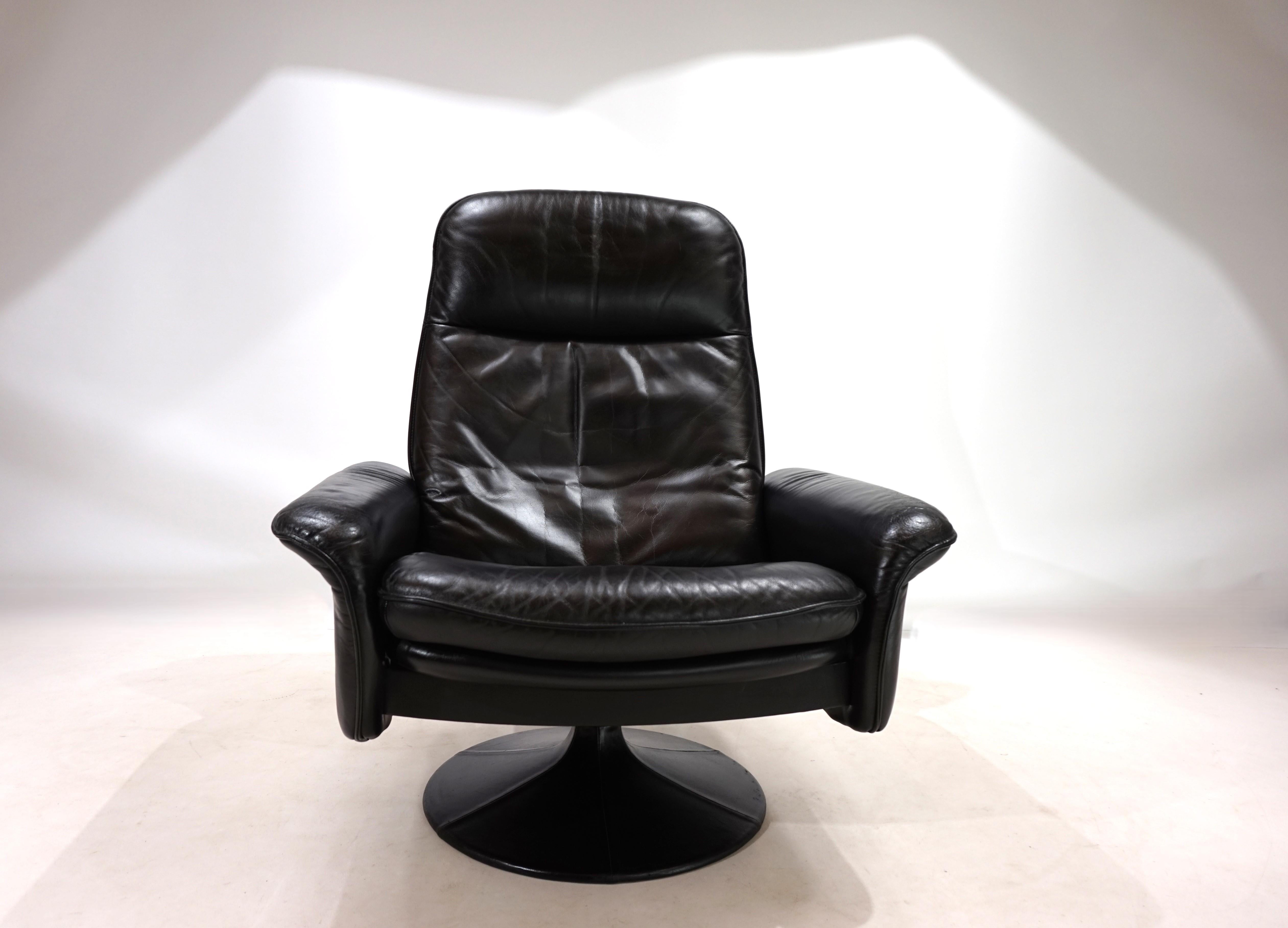 This De Sede DS 50 leather armchair is in excellent condition. The fine black leather shows only minimal signs of wear. The tips of the armrests show a light patina. The armchair can be put into a reclining position by shifting your weight and can