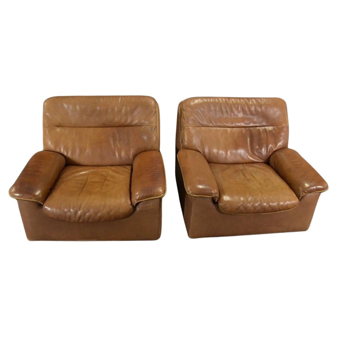 Voici une superbe causeuse en cuir naturel De Sede DS 66 et deux chaises longues simples DS 66 assorties. Cet ensemble est composé d'un cuir épais brun foncé, bien patiné et extrêmement confortable. En état d'origine avec des signes visibles d'usure