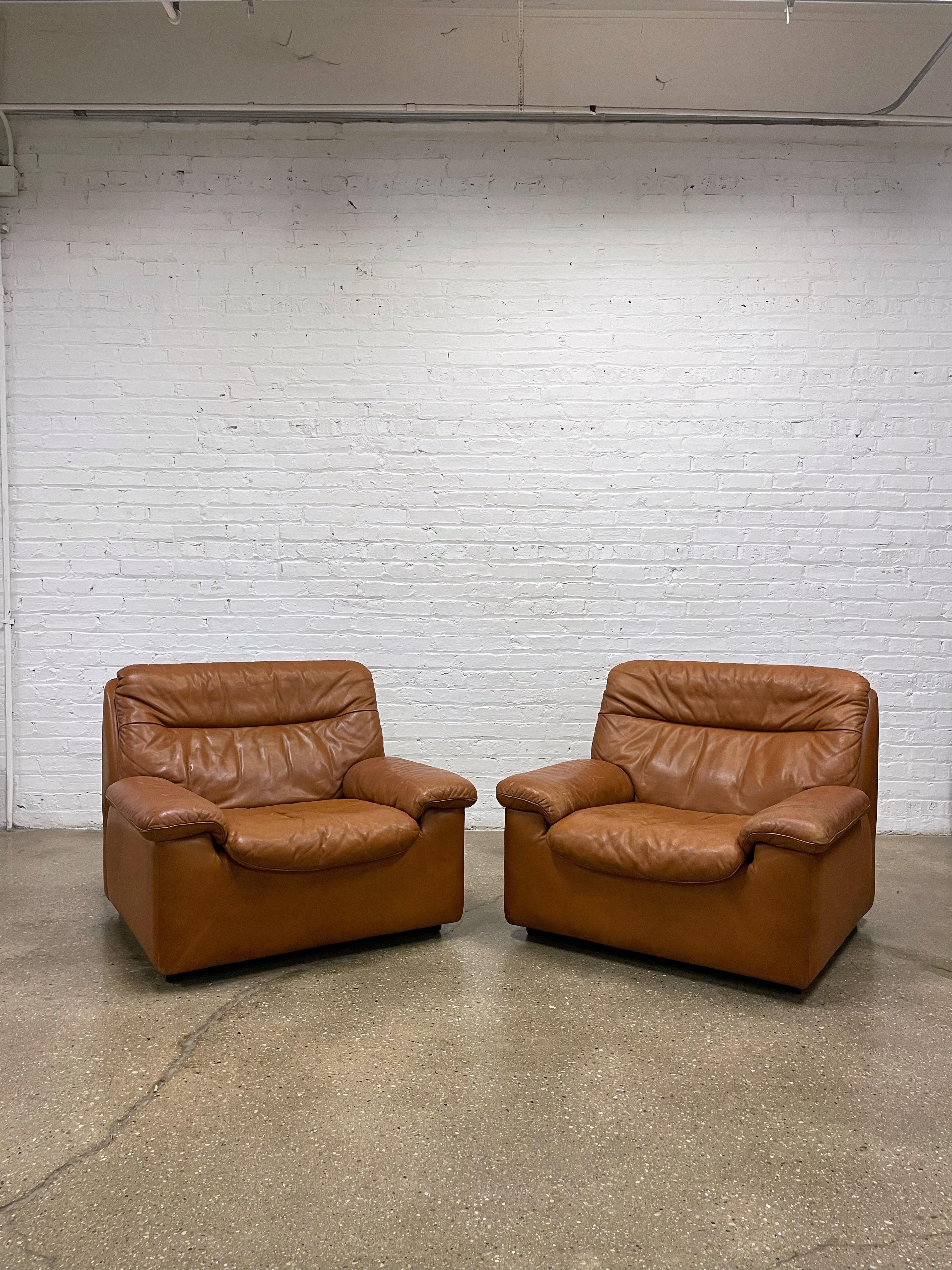 A pair of phenomenal cognac leather lounge chairs by De Sede, made in Switzerland.