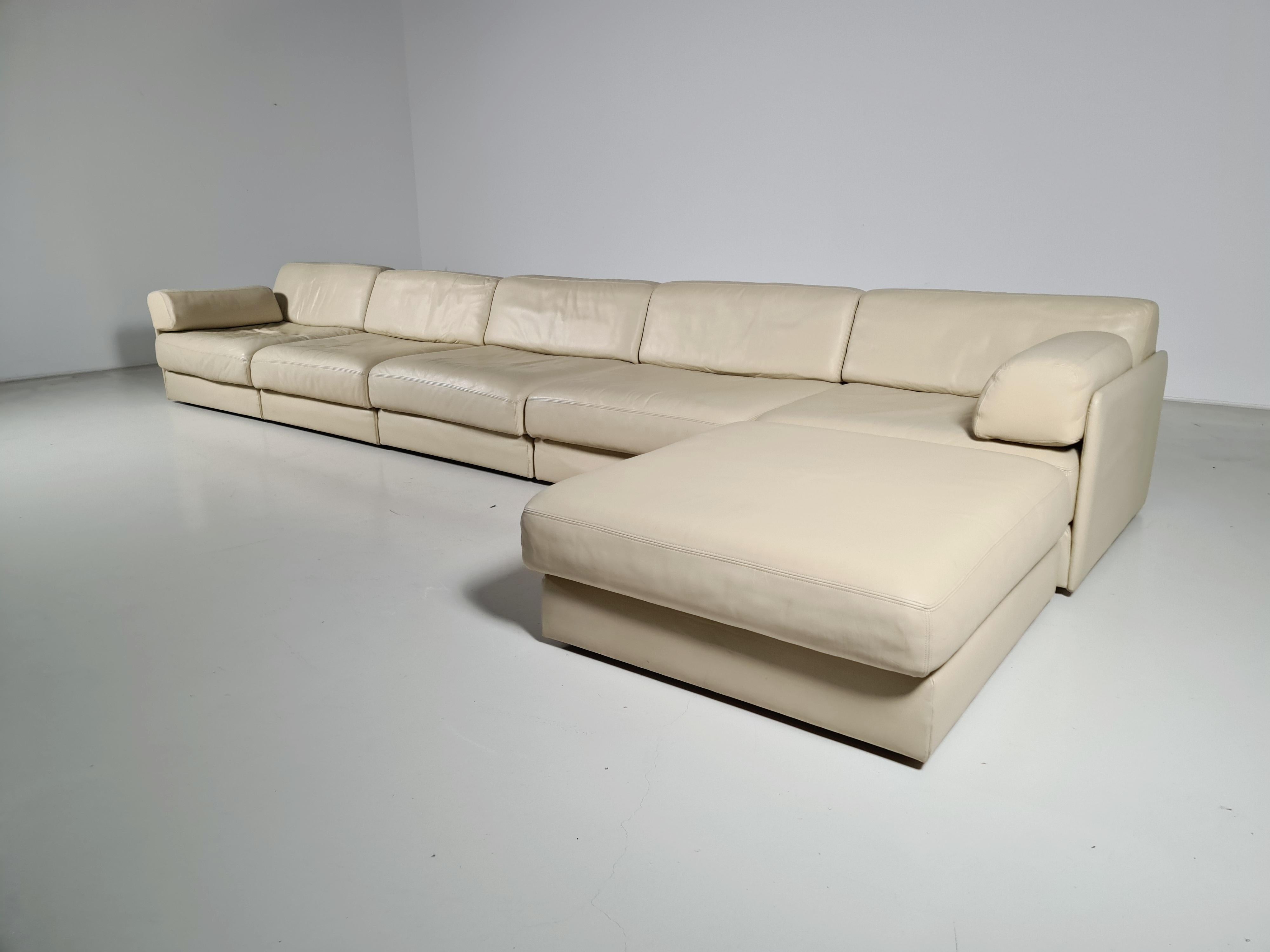 Beautiful 5-piece creme leather modular sofa with ottoman by De Sede from the 1970s. The sofa can be converted into a guest bed in just a few simple steps. Extremely comfortable with a nice patina. Many different settings are possible.