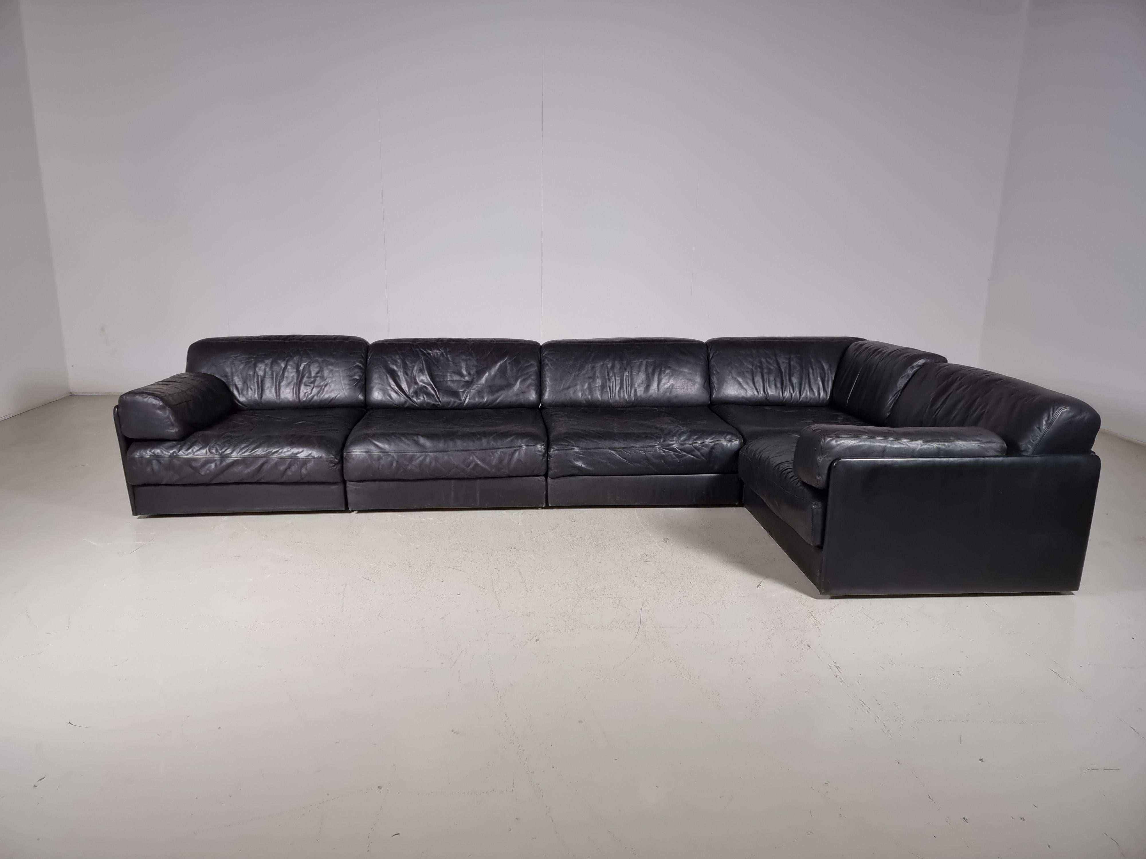 Beautiful 5-piece black leather modular sofa with ottoman by De Sede from the 1970s. The sofa can be converted into a guest bed in just a few simple steps. Extremely comfortable with a nice patina. Many different settings are possible.

Beautiful