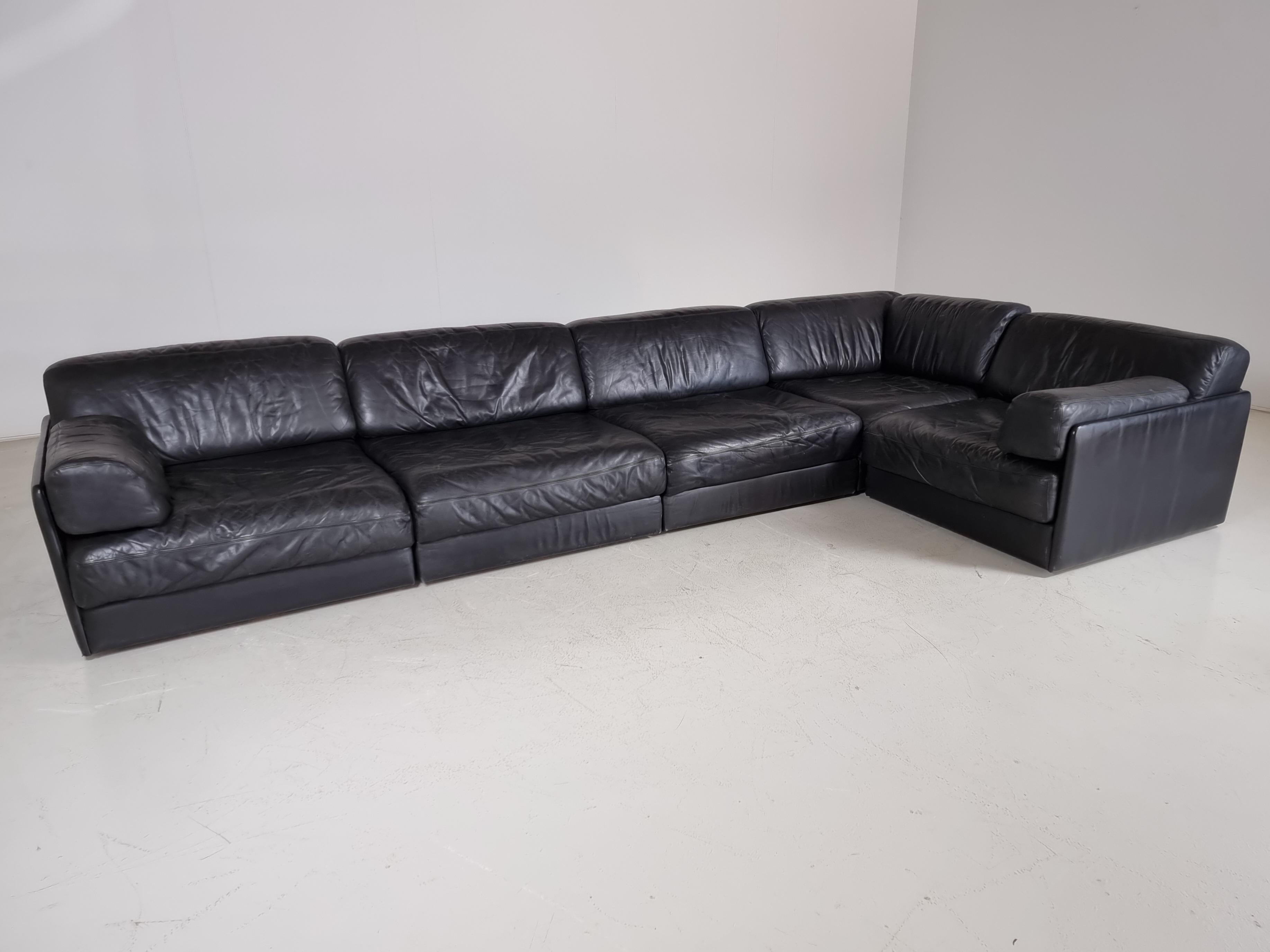 Beautiful 5-piece black leather modular sofa  by De Sede from the 1970s. The sofa can be converted into a guest bed in just a few simple steps. Extremely comfortable with a nice patina. Many different settings are possible.

Beautiful patina.