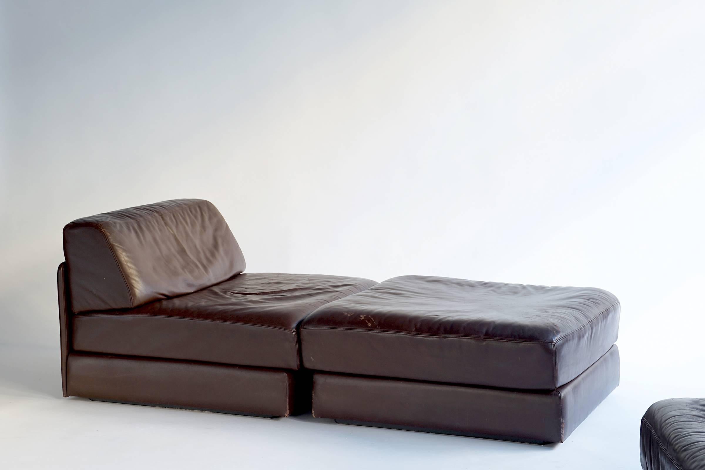 All original leather set comprised of two armless seats and two ottomans. Each of the four pieces flips open into an individual guest bed. Versatile and functional with natural patina.

The two armless seats measure W 36