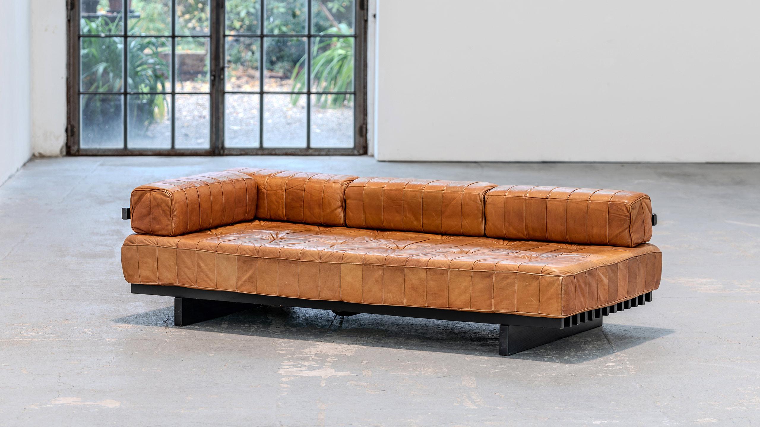 De Sede - DS 80 Sofa + Daybed in cognac patchwork leather
1973 by De Sede Design Team

De Sede DS-80 Patchwork Daybed with armrest.
The daybed has a black lacquered wooden slatted frame, the backrest and armrest of which can be freely positioned and