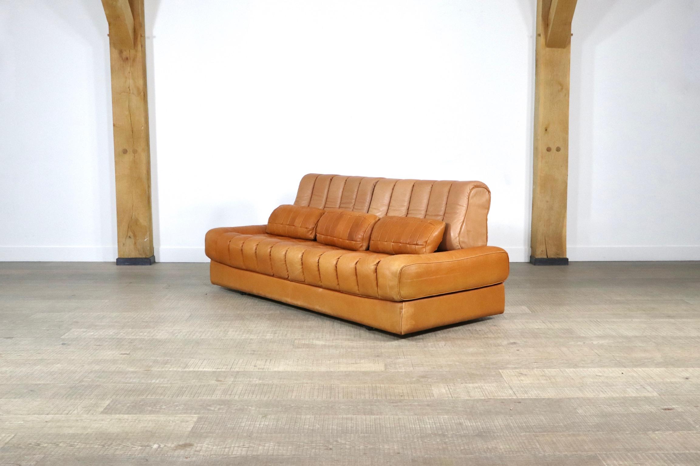 Stunning De Sede DS-85 sofa/daybed in cognac leather. This sofa is a special edition, which can be recognised through the lighter coloured back cushions. The sofa can be folded into a large double bed, which makes it the ideal sofa for a small space