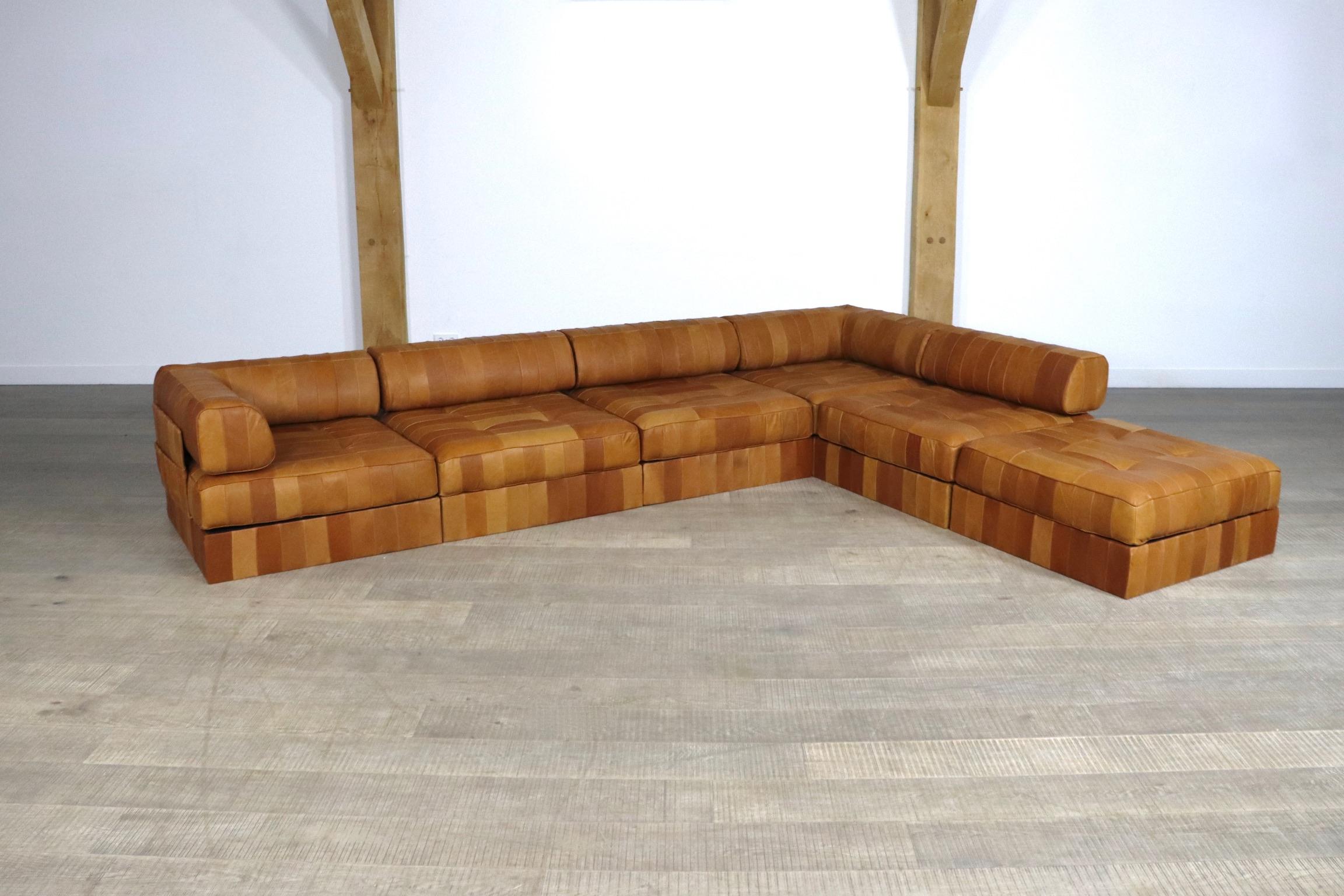 Beautiful DS-88 patchwork leather sofa designed and manufactured by De Sede, Switzerland 1970s. The sofa consists of 6 elements, of which one ottoman, each with a cognac leather patchwork base, cushion and back cushion made from the same soft