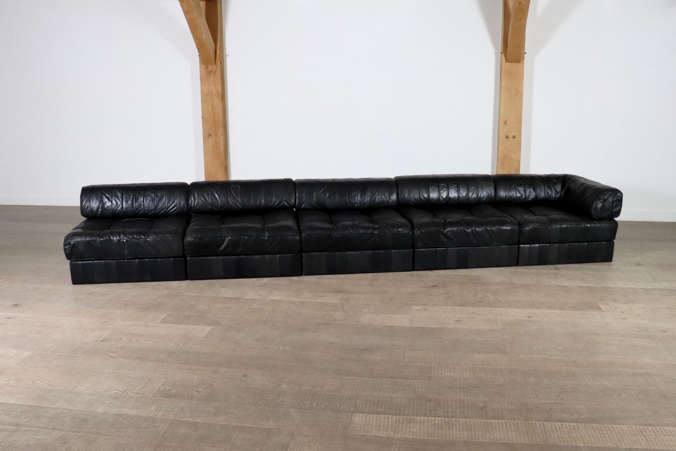 Fantastique canapé en cuir patchwork DS-88 conçu et fabriqué par De Sede, Suisse, années 1970.

Le canapé modulaire se compose de cinq éléments, dont un d'angle, chacun avec une base en patchwork de cuir noir, un coussin d'assise et un coussin de