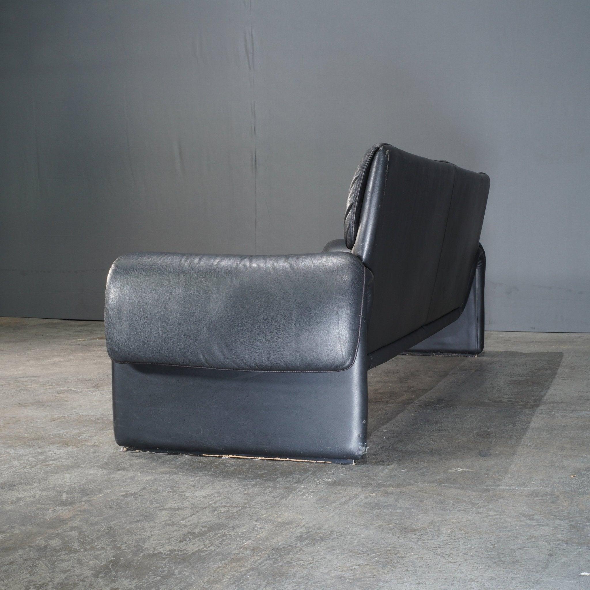 The De Sede DS2011 Black Leather Sofa embodies the perfect balance of modern minimalism and unparalleled comfort. Expertly crafted in Switzerland, this two-seater sofa features premium black leather upholstery, known for its exceptional softness and