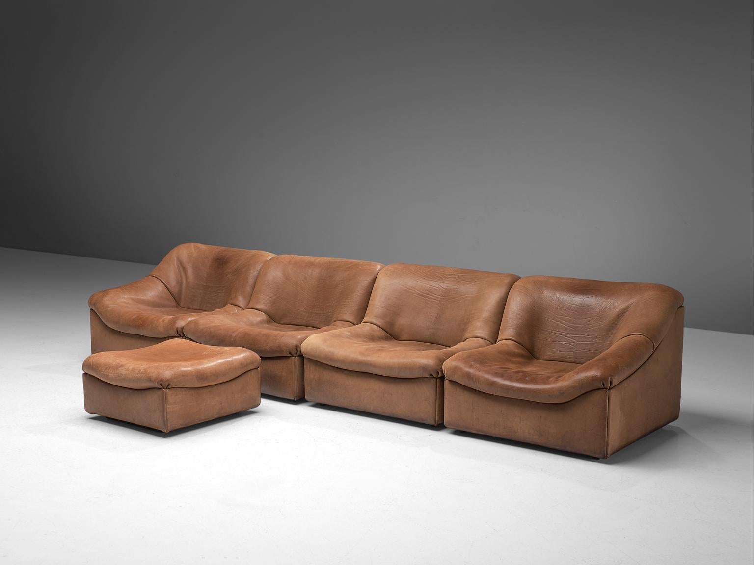 De Sede, DS46 sectional sofa with ottoman, cognac buffalo leather, Switzerland, 1970s.

Comfortable four-modular sectional sofa with ottoman in thick buffalo leather by De Sede. This model features a solid base with a rounded, bulky seat and a