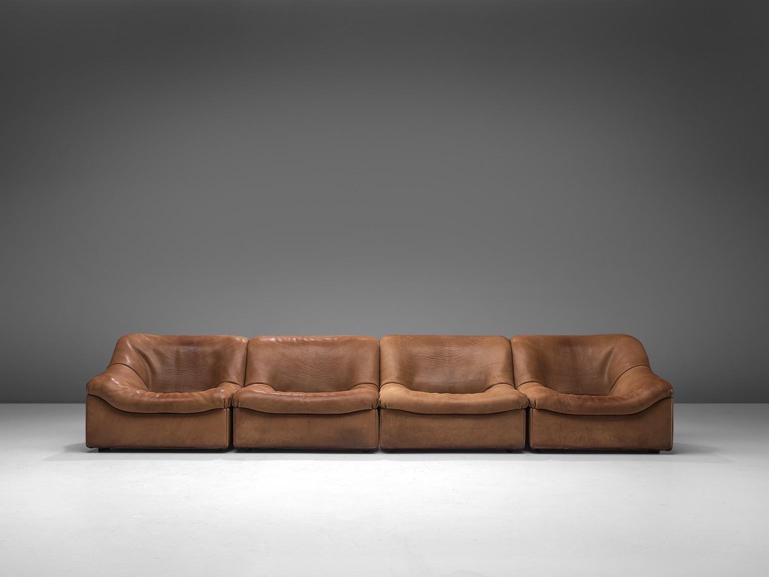 De Sede, DS46 sectional sofa with ottoman, cognac buffalo leather, Switzerland, 1970s.

Comfortable four-modular sectional sofa with ottoman in thick buffalo leather by De Sede. This model features a solid base with a rounded, bulky seat and a