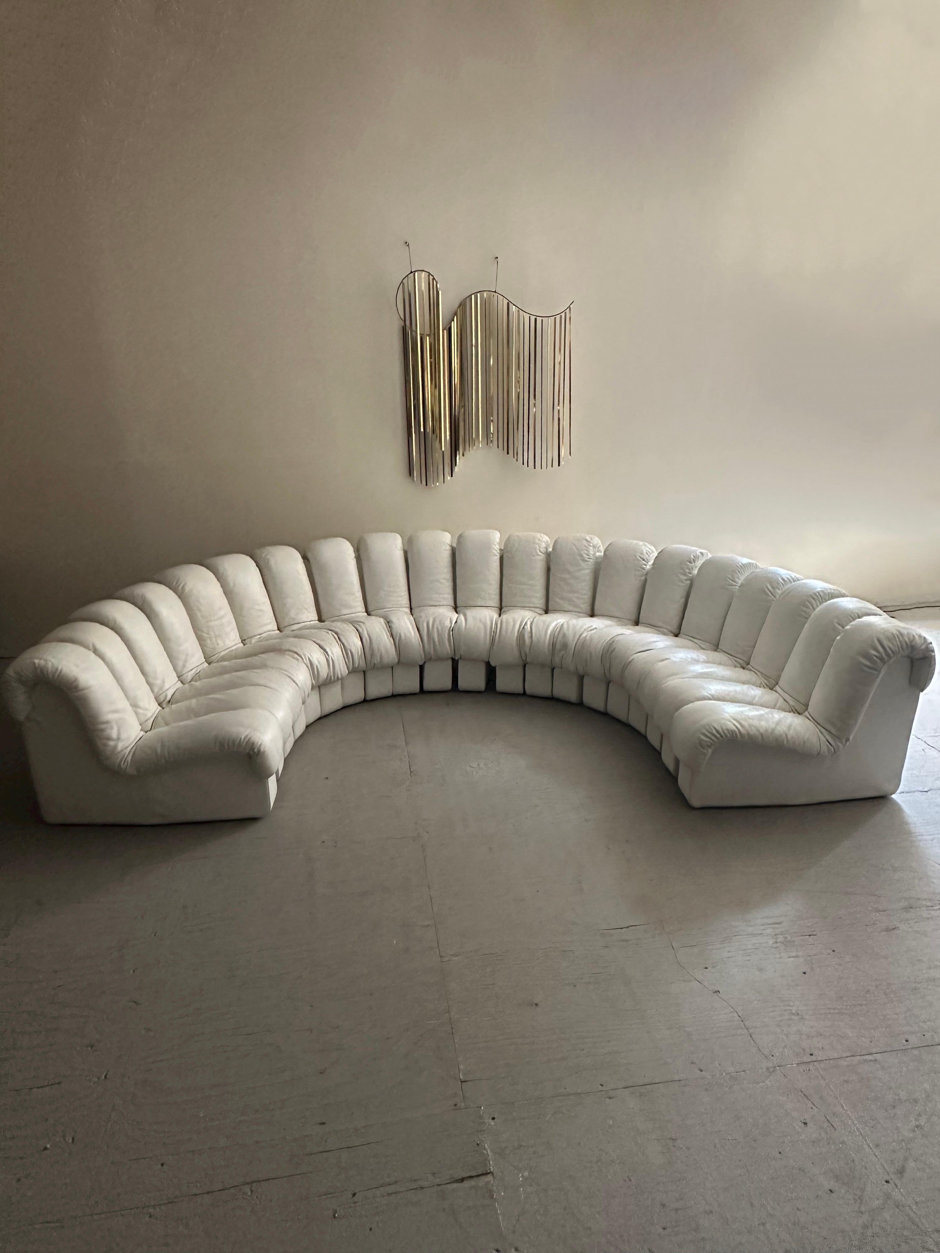A monumental Mid-Century classic designed in collaboration by Ueli Bergere, Elenora Peduzzi-Riva, Heinz Ulrich and Klaus Vogt at De Sede, Switzerland. Comes wrapped in original white leather upholstery. This modular sectional sofa with endless