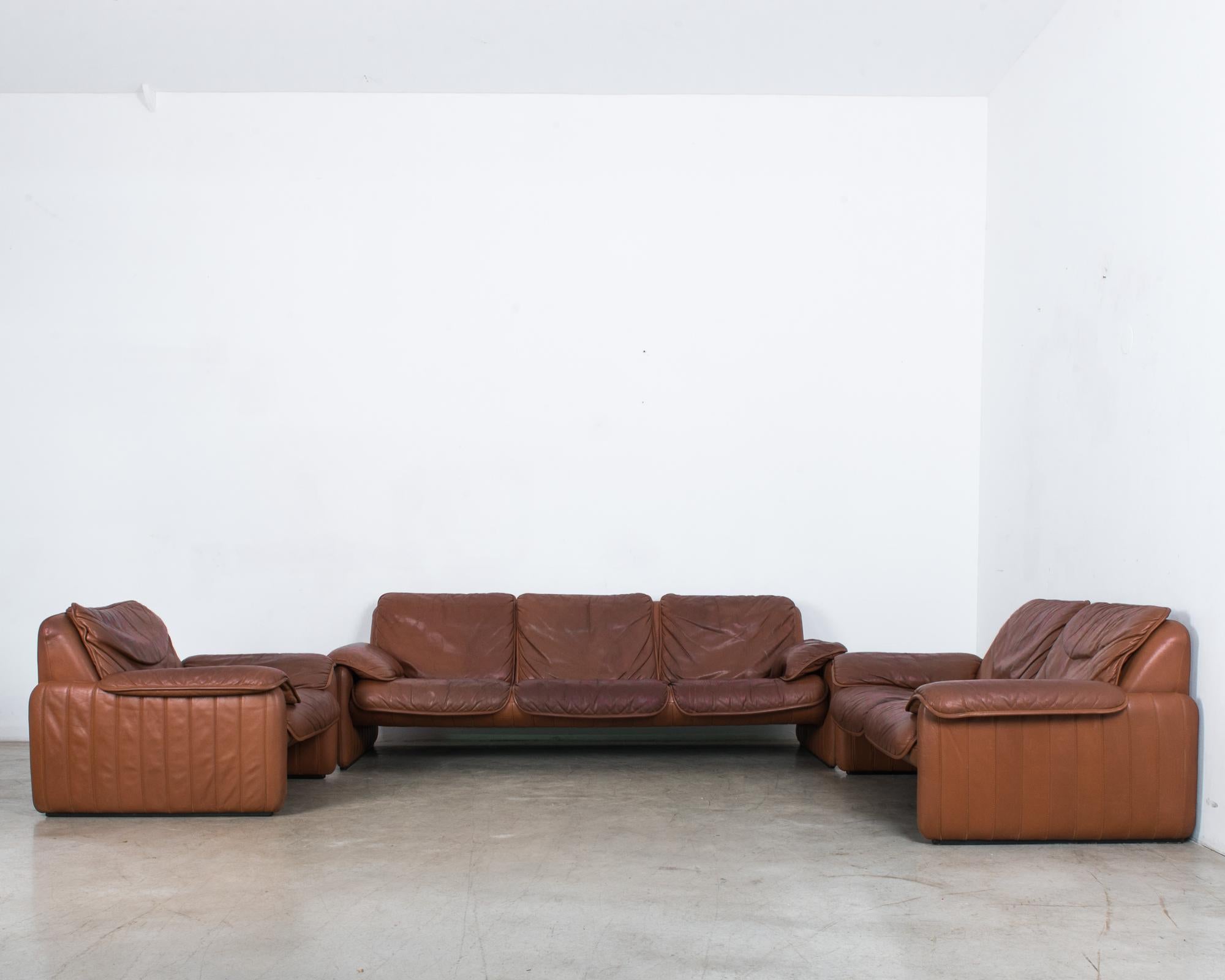 A classic model, the DS 61 by Swiss manufacturer De Sede. This set features an armchair, loveseat, and standard sofa. Known both for their leather craftsmanship and their contemporary designs. This sofa set features a distinctive midcentury