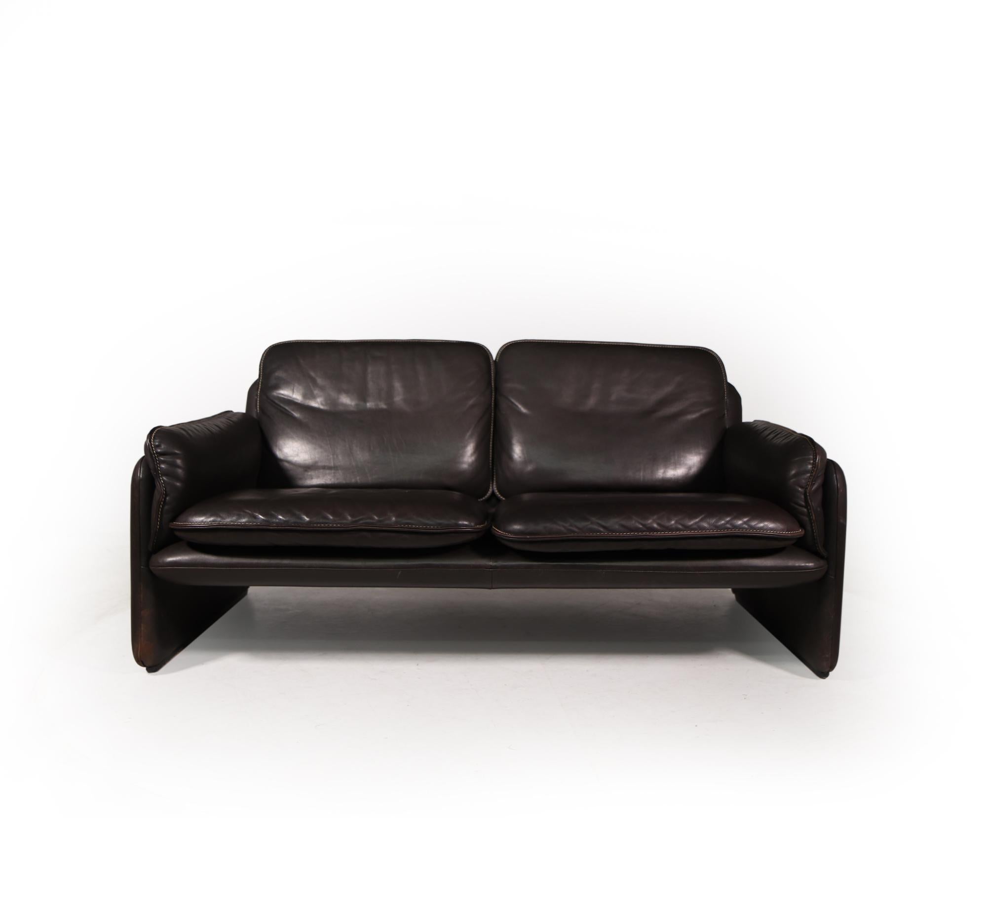 De Sede DS 61 High-quality leather two seat sofa. It is covered with quality thick dark brown leather upholstery with white stitching , and features a heavy wooden frame. original vintage condition throughout, with no rips tears or repairs to the