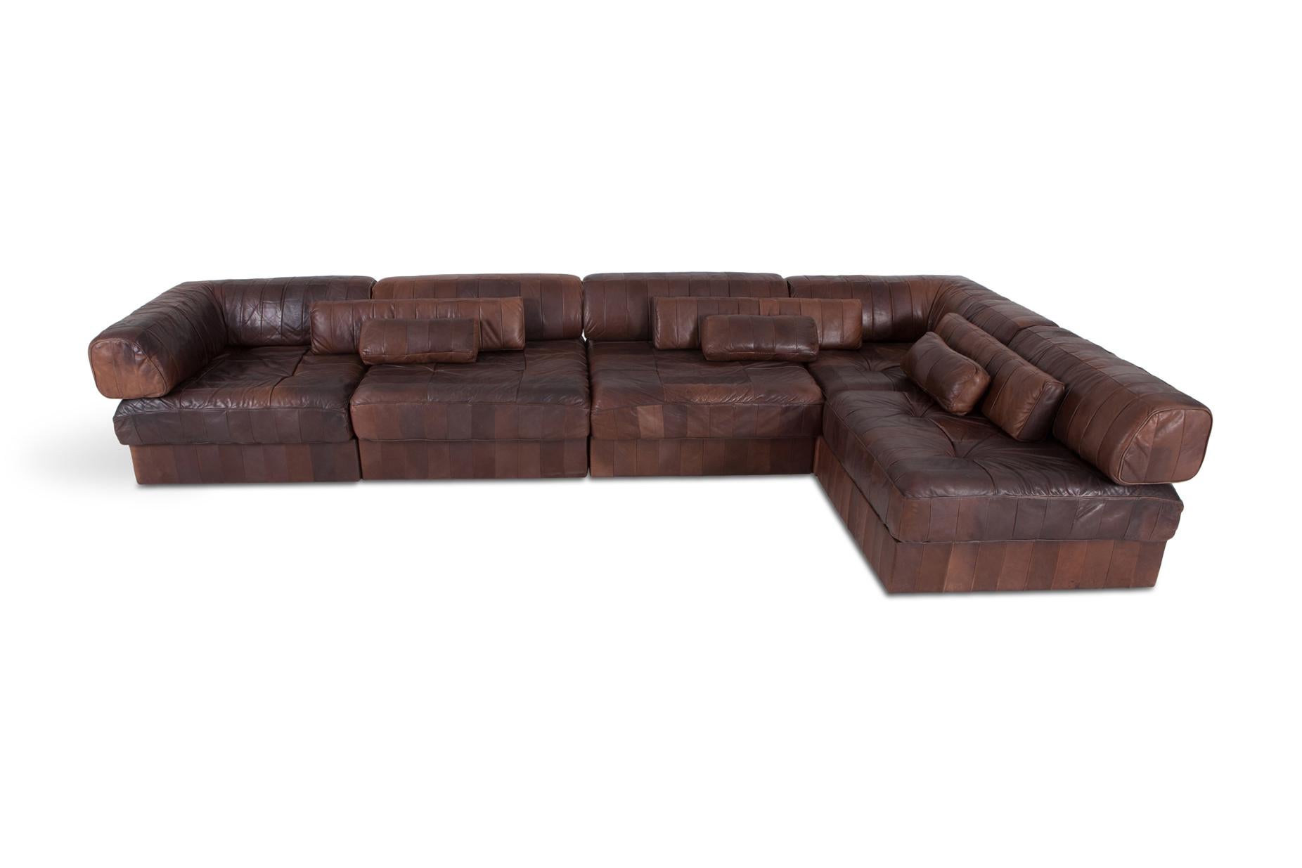 DS 88 sectional sofa in patchwork brown-cognac leather. 

Hand built in the 1970s to incredibly high standards by De Sede craftsman in Switzerland.   Made of five sections, each with a base leather patchwork cushion and a back cushion made from the