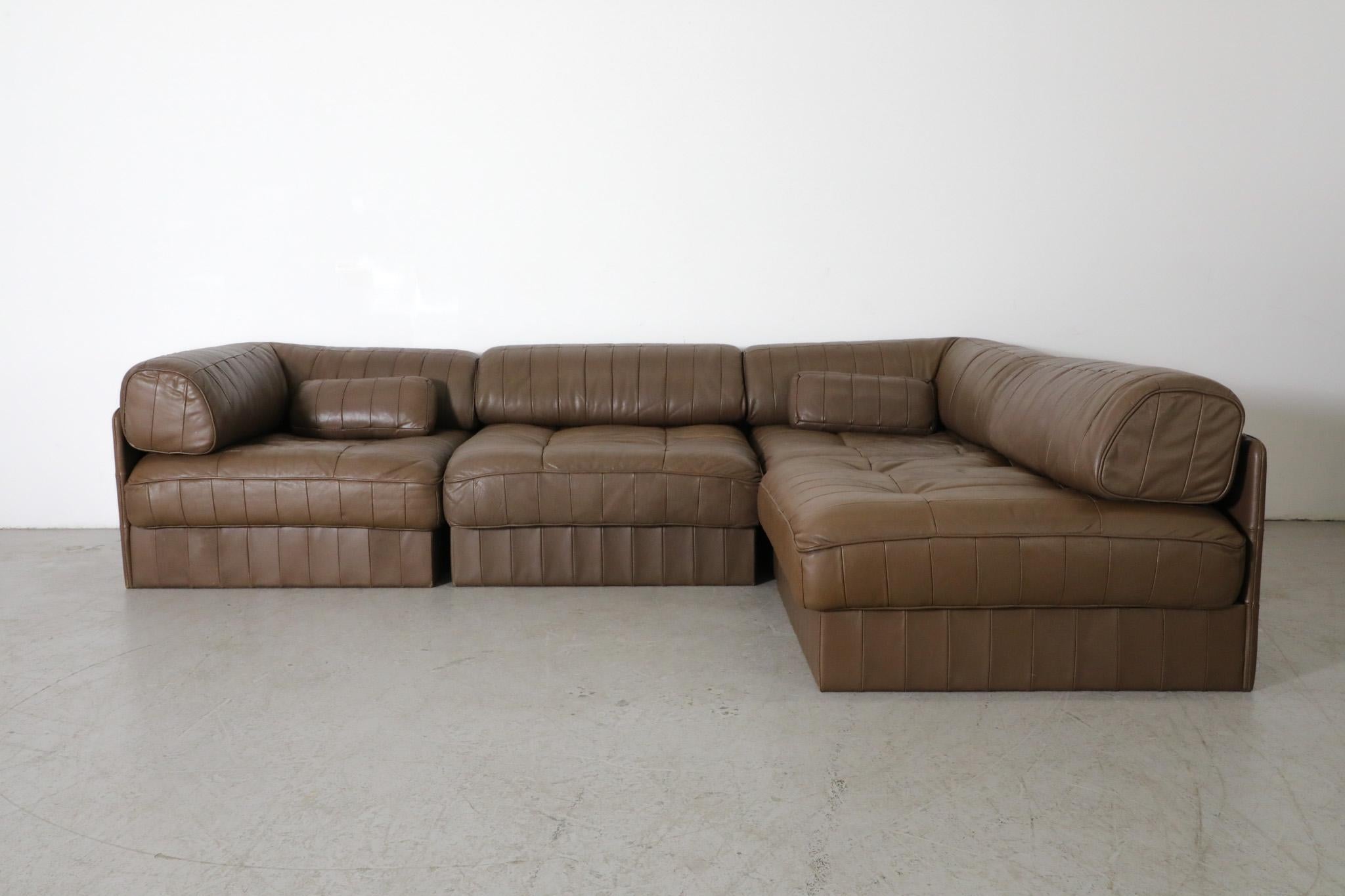 Swiss, De Sede manufactured DS88 modular patchwork sofa in chocolate brown leather. Consists of two corner sections and two middle sections and can be arranged in a straight line or and L shape. Sofa comes with two small throw pillows.  De Sede has