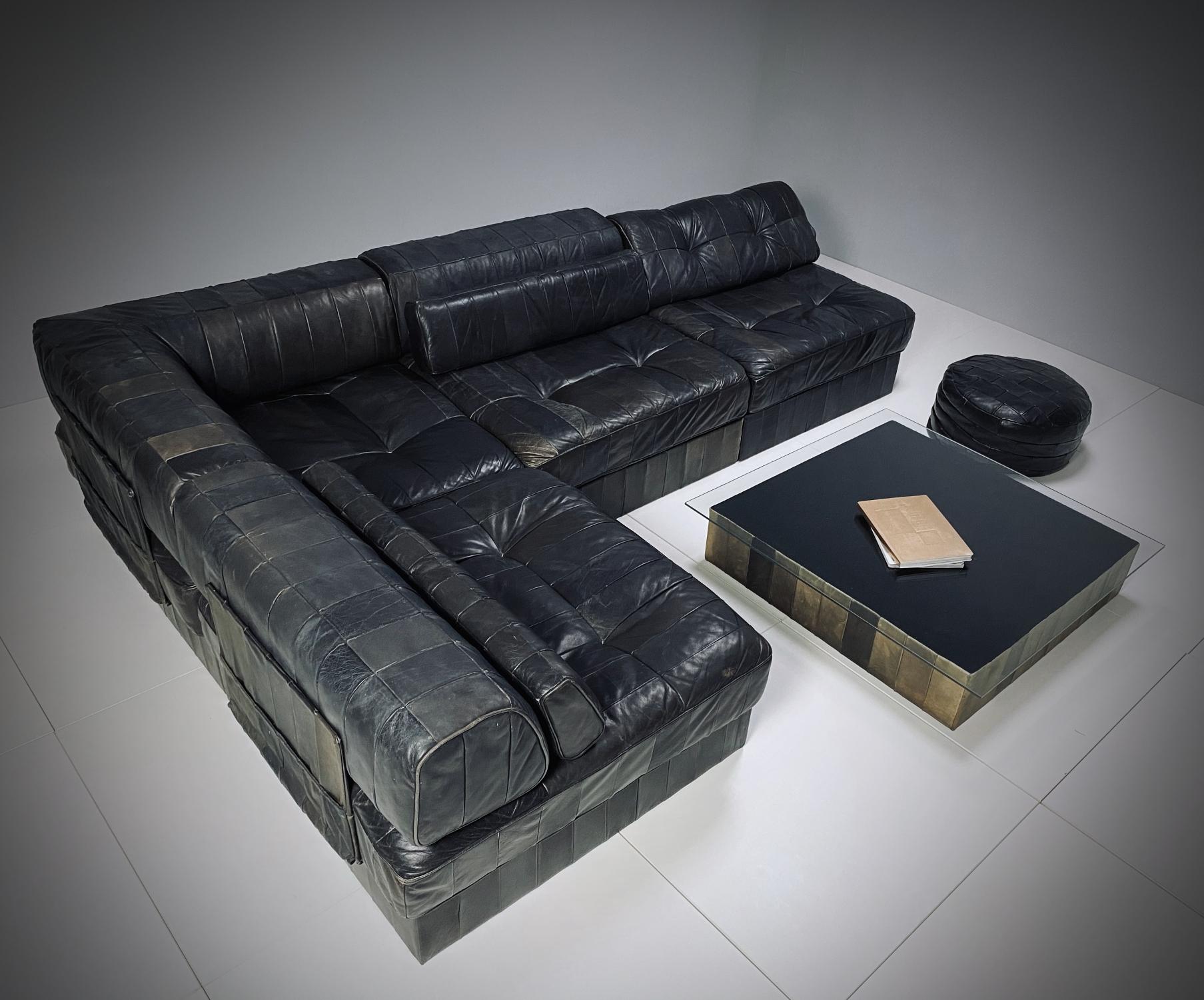 DeSede DS 88 modular sofa with coffee table and pouf in dark green/black patchwork leather. The set is made of high quality soft leather, typical of DeSede. The sofa consists of four sections - each with a base, cushion and a back cushion, all of