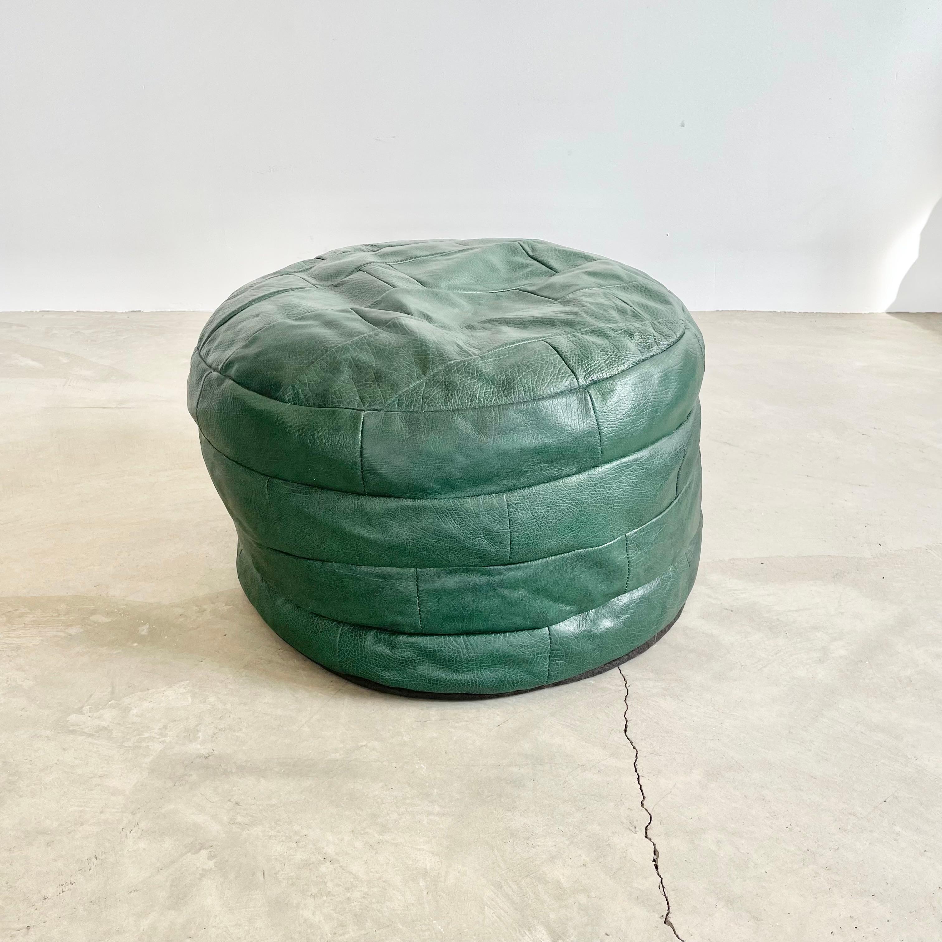 Stunning emerald green leather pouf/ottoman by Swiss designer De Sede with square patchwork. Handmade with wonderful light patina. Gorgeous accent piece. Good vintage condition with soft supple leather. Brand new filler. Unusual color. Perfect