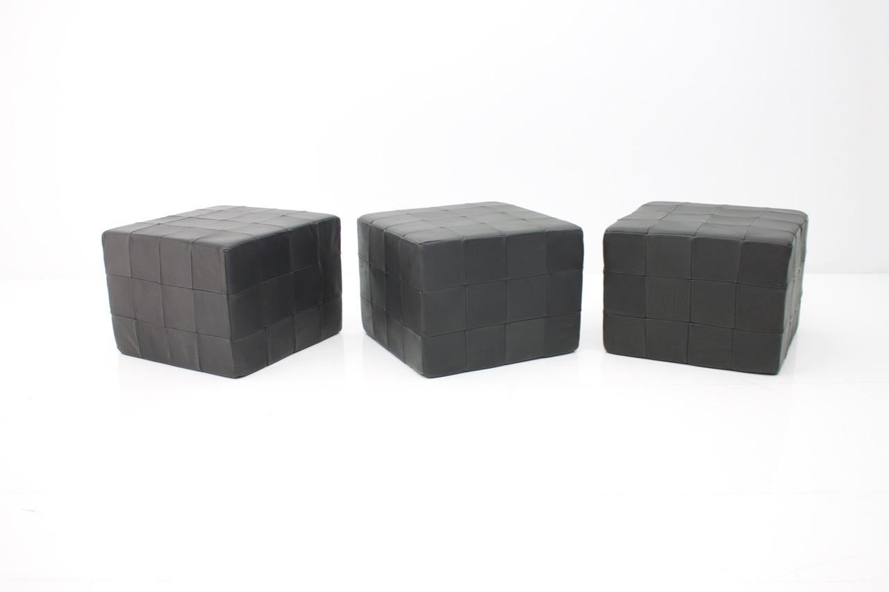Set of three cube stools by De Sede in black leather.

Very good condition.