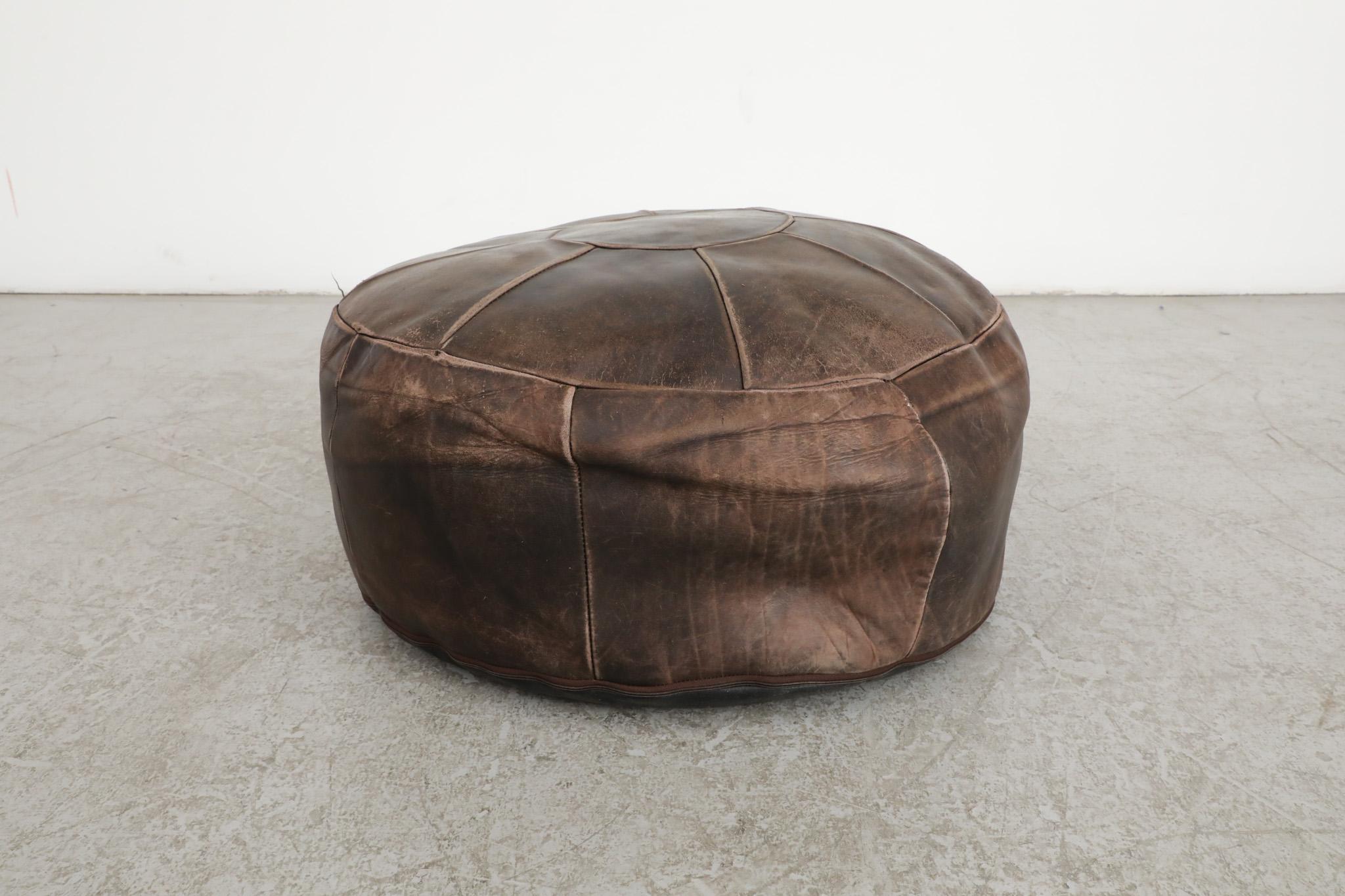 Mid-Century, De Sede Inspired leather patchwork ottoman. Its sturdy and comfortable soft form frame in original condition with some visible wear and light patina, all consistent with its age and use.