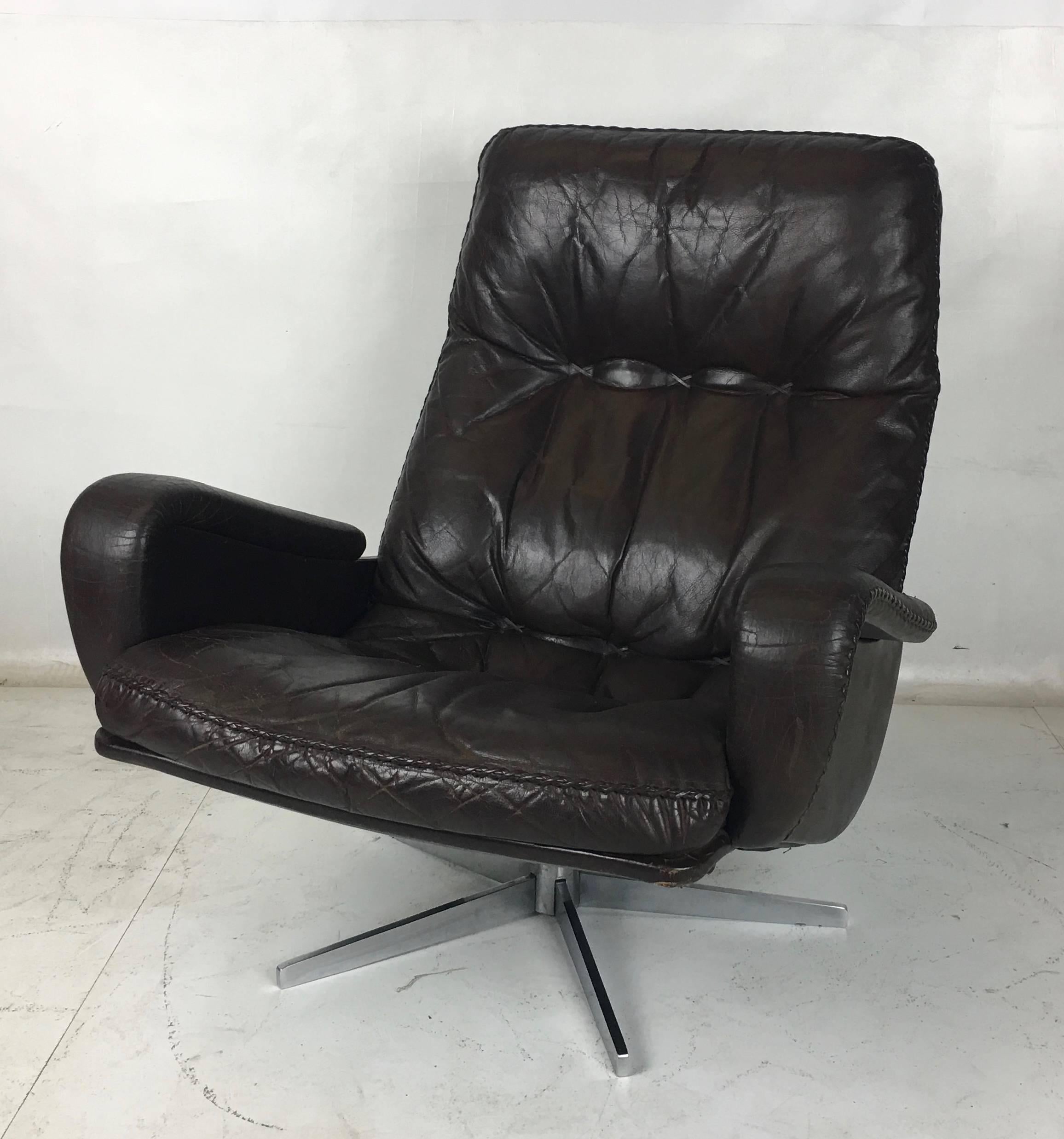 Ultra comfortable De Sede S231 high-back lounge chair and ottoman in beautifully worn condition. This chair is built like a tank and everything about the frame, base, and foundation is in perfect condition. The chocolate brown leather with