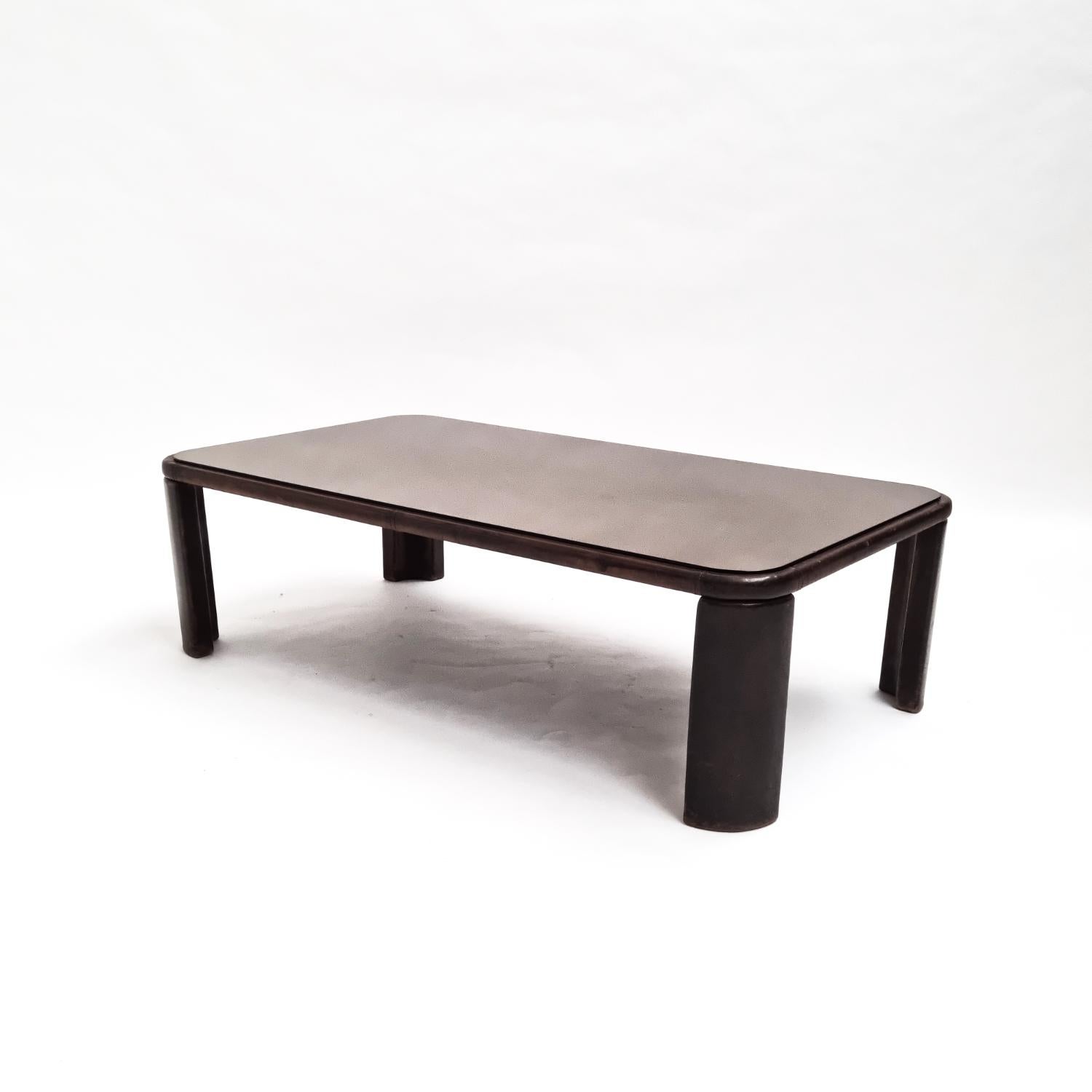 Améliorez votre espace de vie avec cette table basse sophistiquée de De Sede datant des années 1970. Entièrement recouverte de cuir brun foncé riche et surmontée de verre fumé, cette pièce ajoute une touche d'élégance et de luxe. Mesurant 15,75