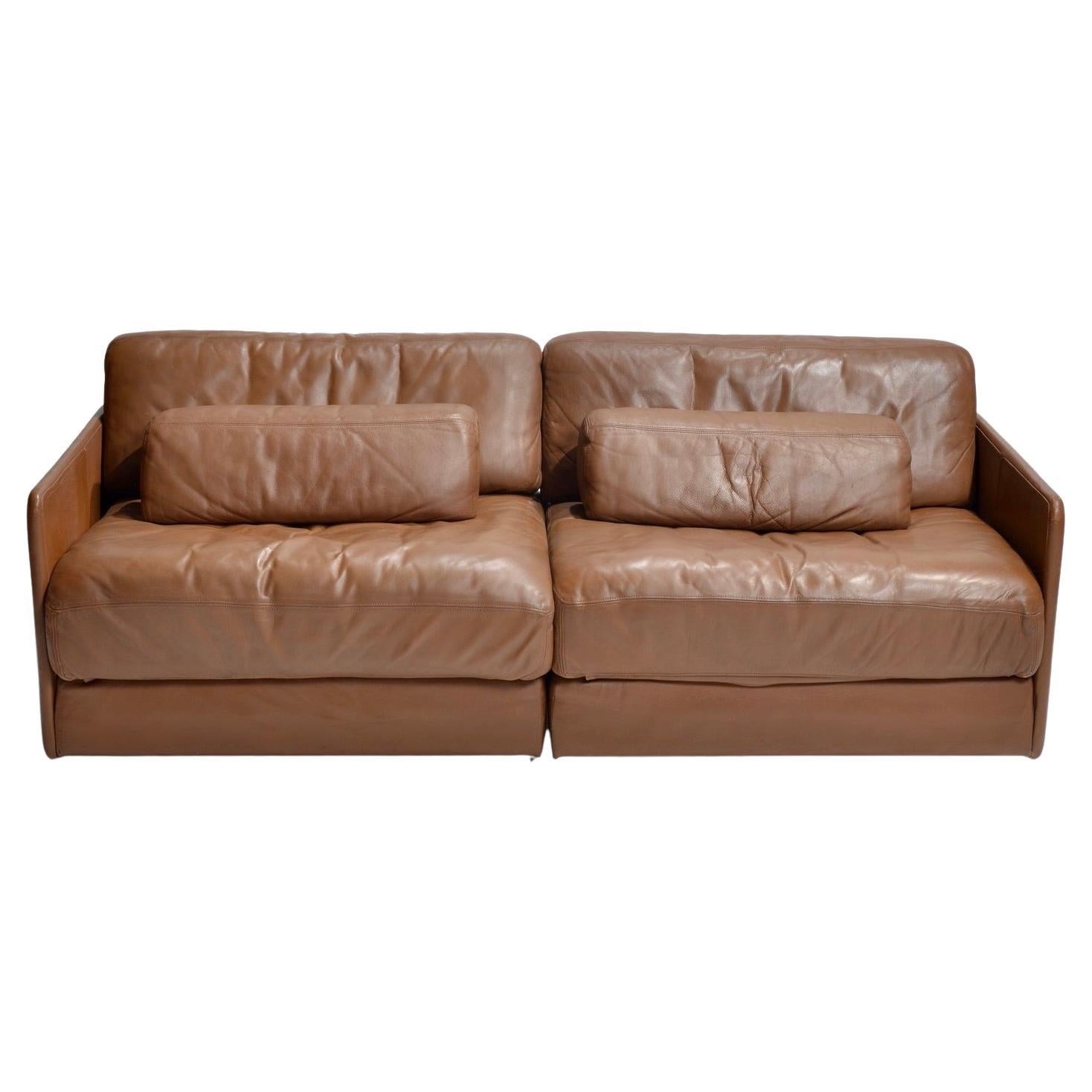 De Sede love seat double seat sectional of high quality leather with beautiful patina giving it an aged premium leather look. Functions in multiple configurations as well as two day beds. Unique style and superior craftsmanship make this a highly