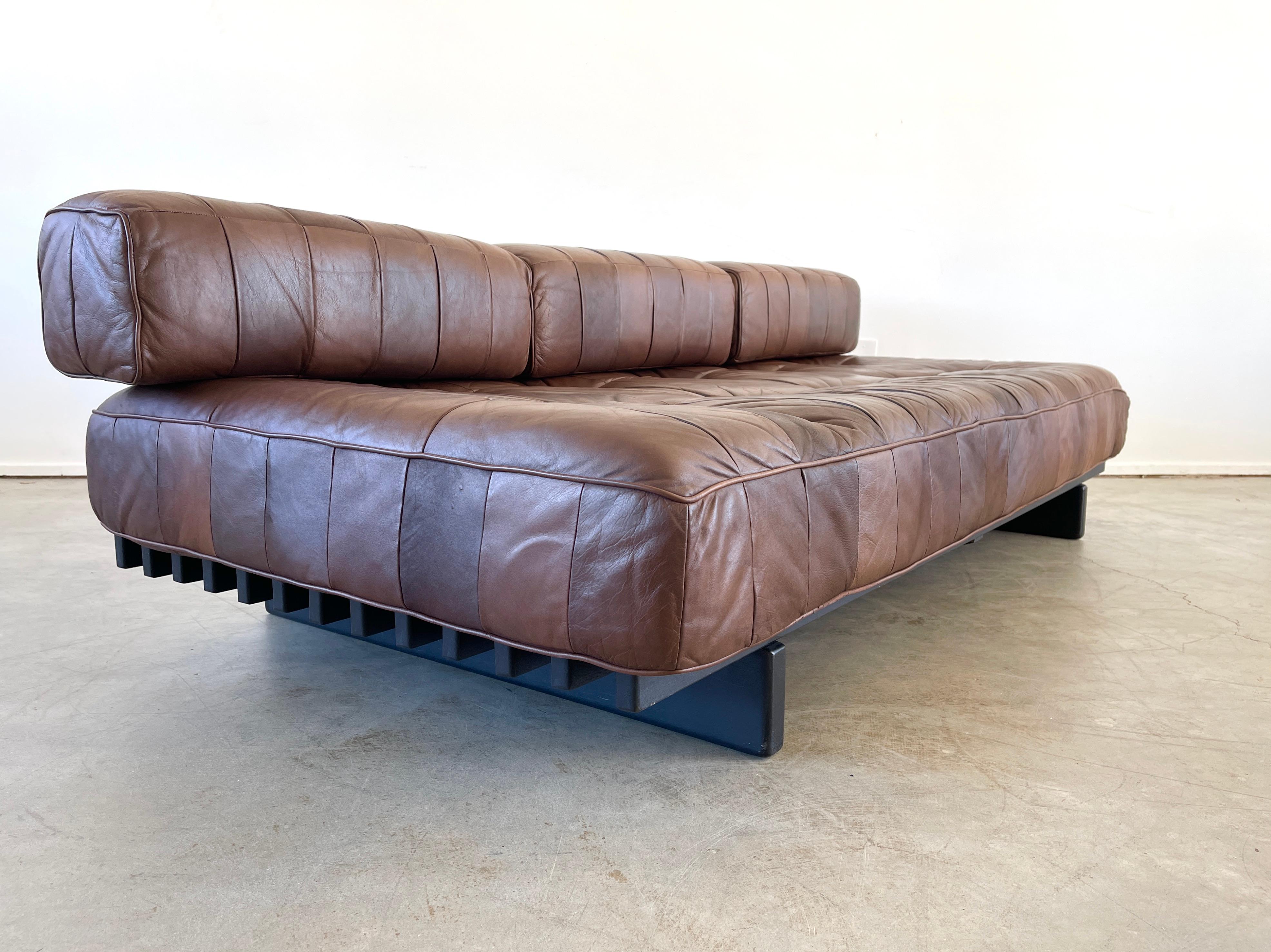Wonderful De Sede daybed DS 80 in chocolate brown leather
Signature patchwork leather has wonderful patina and sits on a black slatted wood frame.