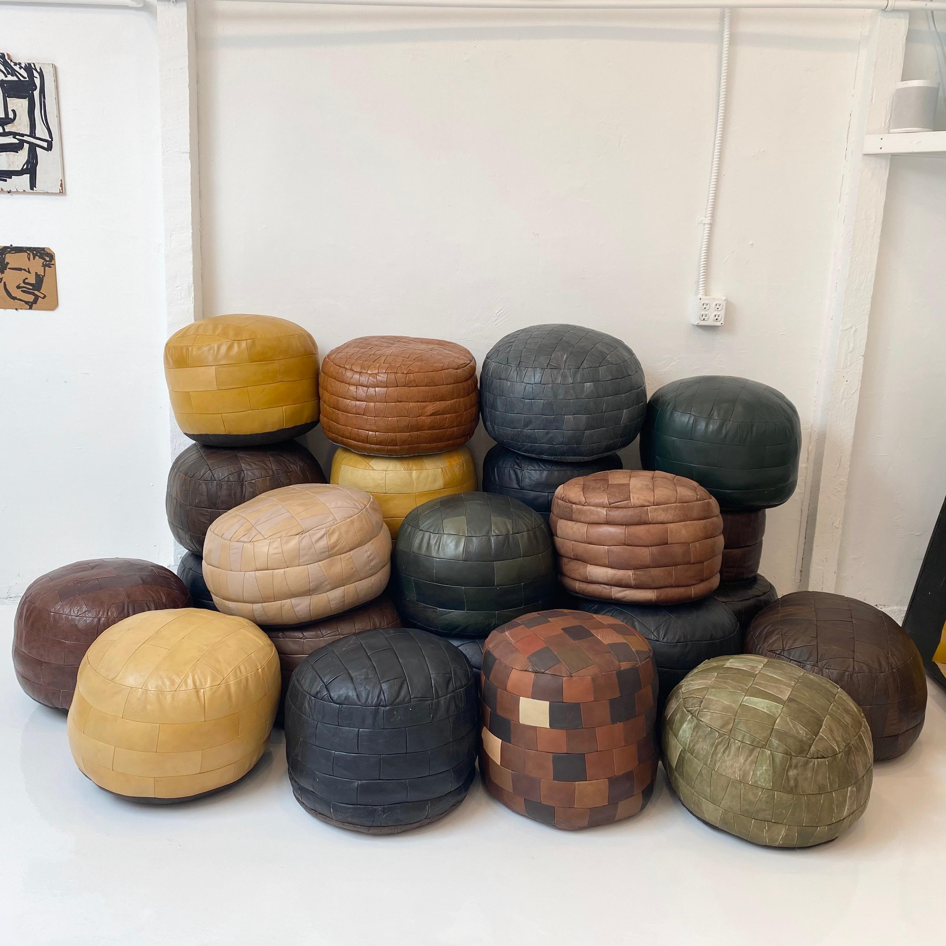 Massive collection of vintage leather poufs by De Sede of Switzerland. Perfect for a living room, boutique hotel or retail store. Good vintage condition. Wear and patina vary throughout. 

24 unique poufs, priced individually in separate listings.