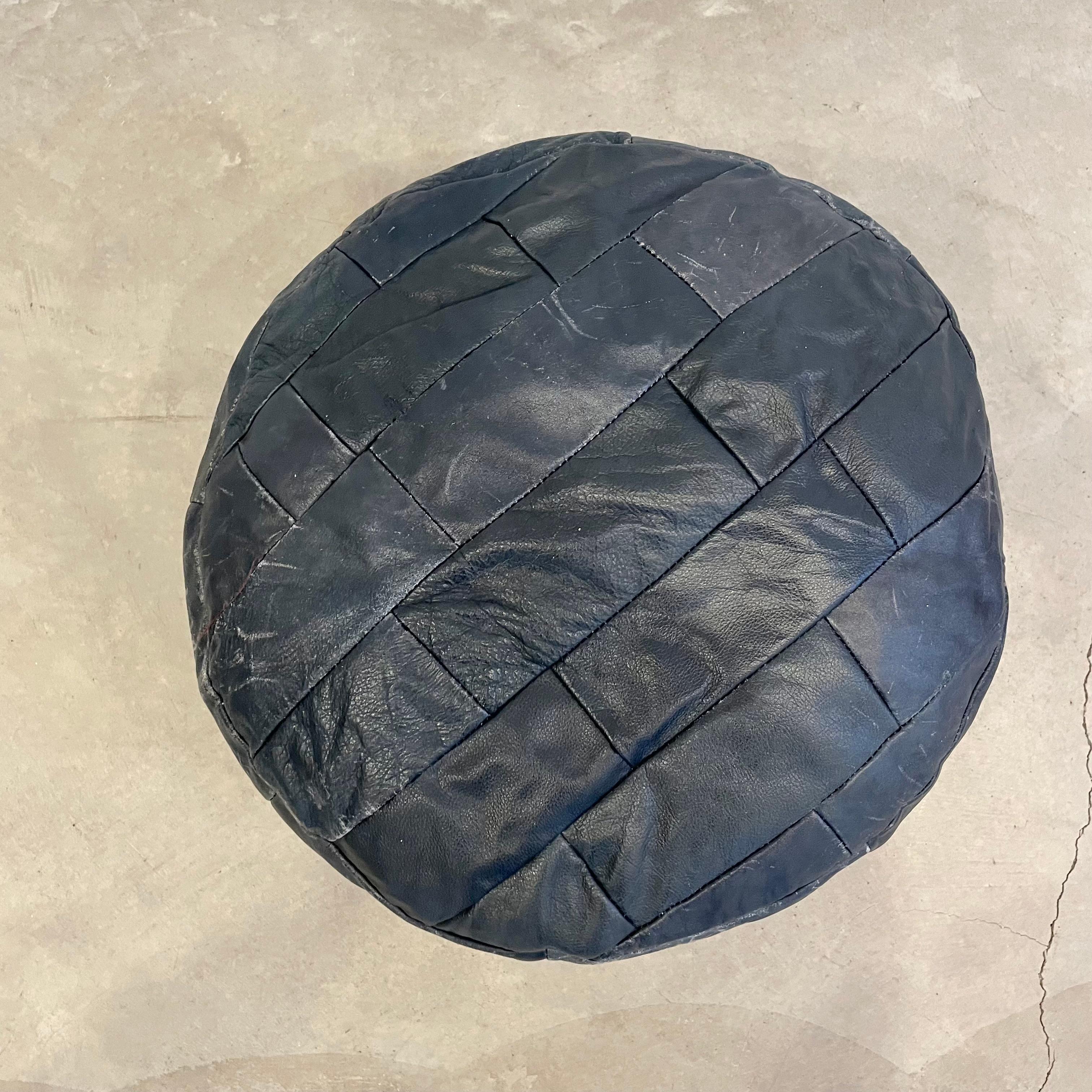Lovely navy blue leather pouf/ottoman by Swiss designer De Sede with square patchwork. Handmade with wonderful faded patina. Gorgeous accent piece. Good vintage condition. Wear appropriate with age. Brand new filler. Perfect living room decor, foot